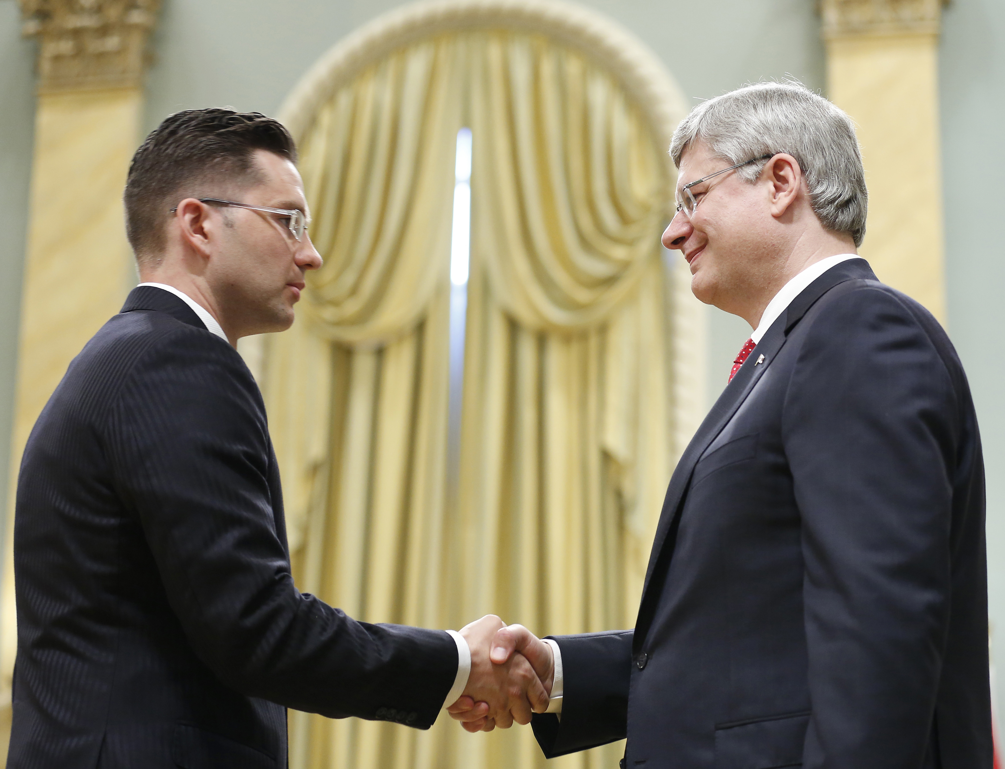 Pierre Poilievre (left) shakes hands with then-Canadian Prime Minister Stephen Harper in 2013
