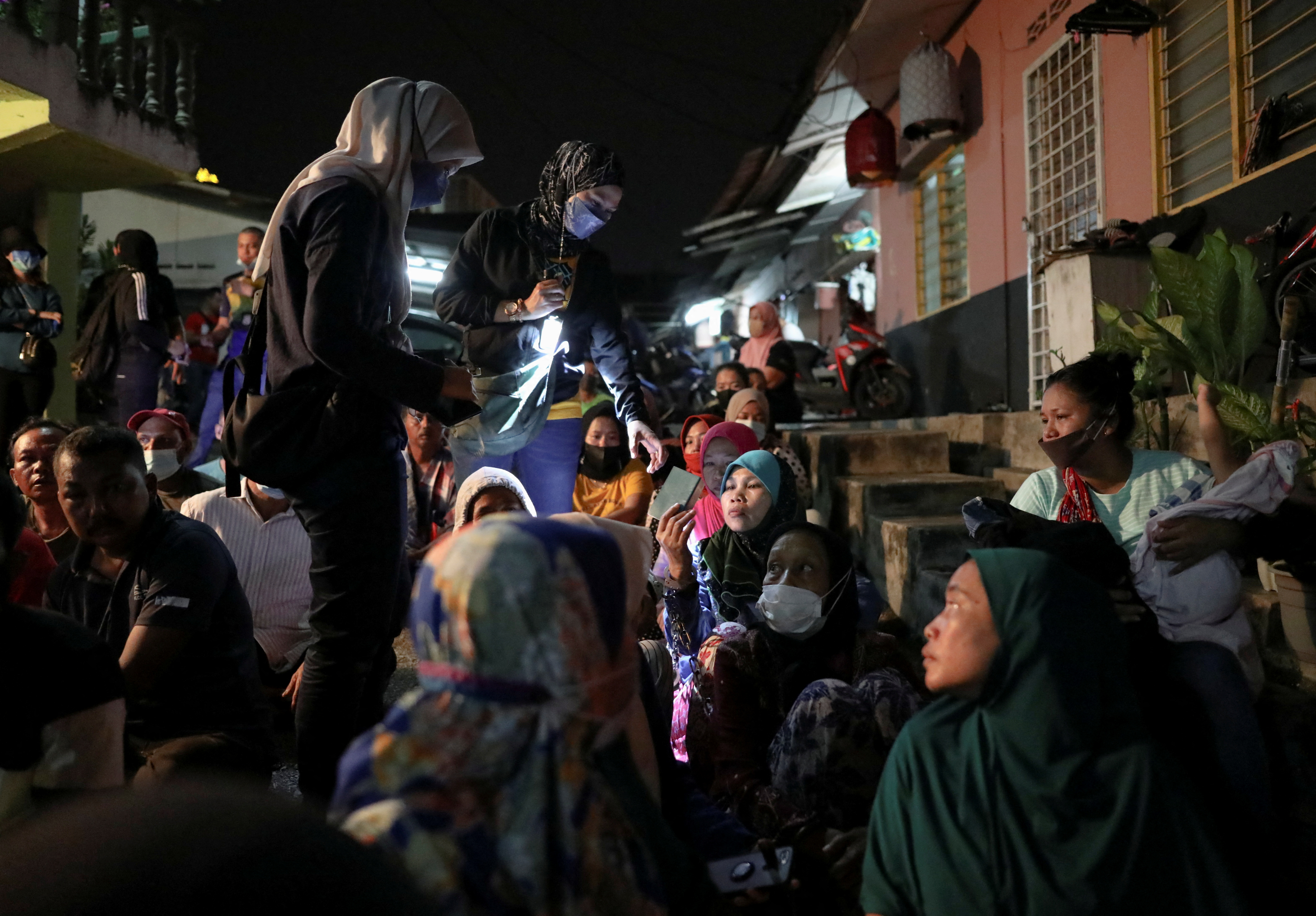 Immigration officers check documents during a night time raid in Kuala Lumpur