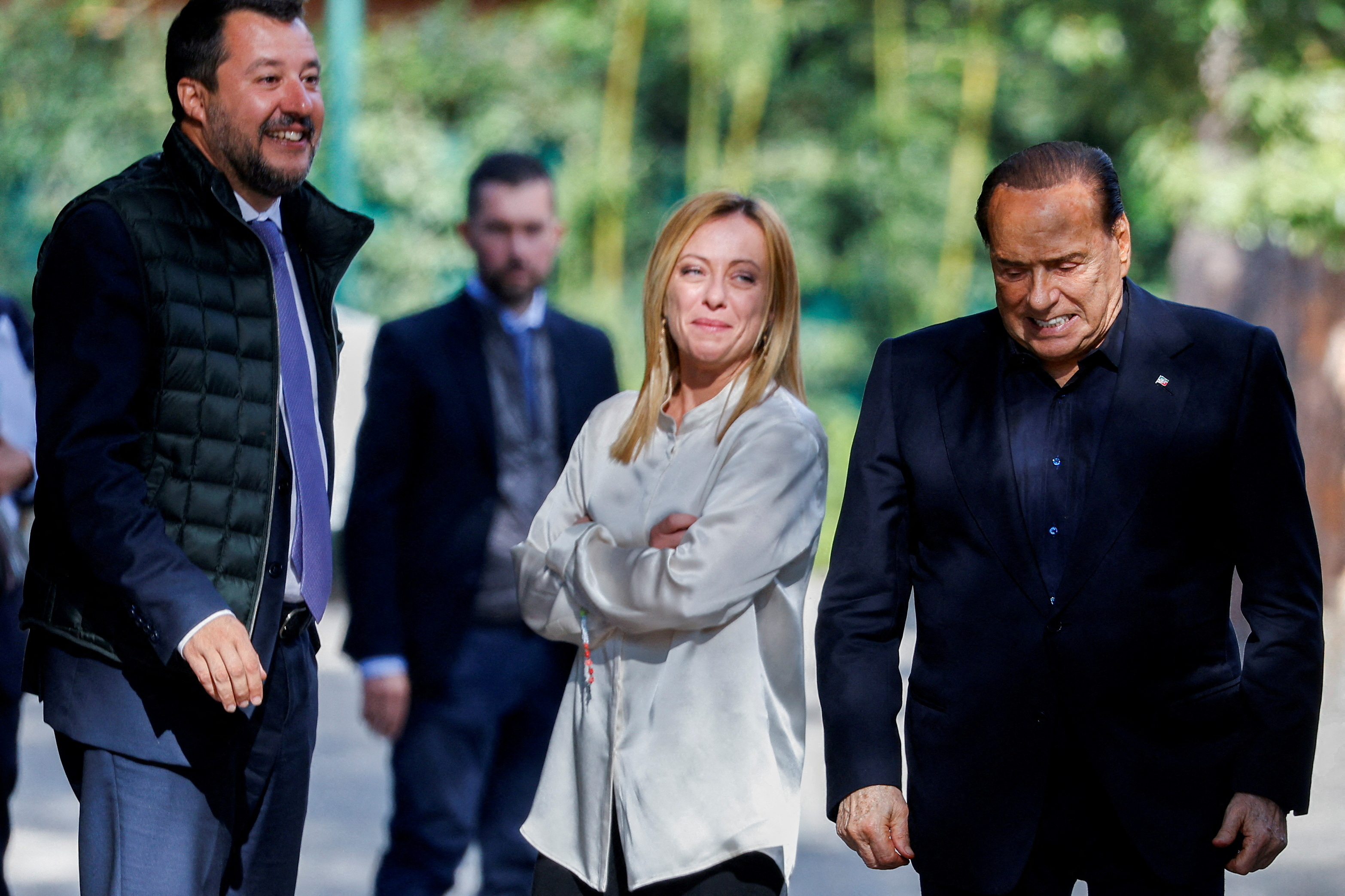 Former Italian prime minister and leader of the Forza Italia party Silvio Berlusconi (R) reacts at the end of a meeting with League leader Matteo Salvini (L) and Brothers of Italy leader Giorgia Meloni i