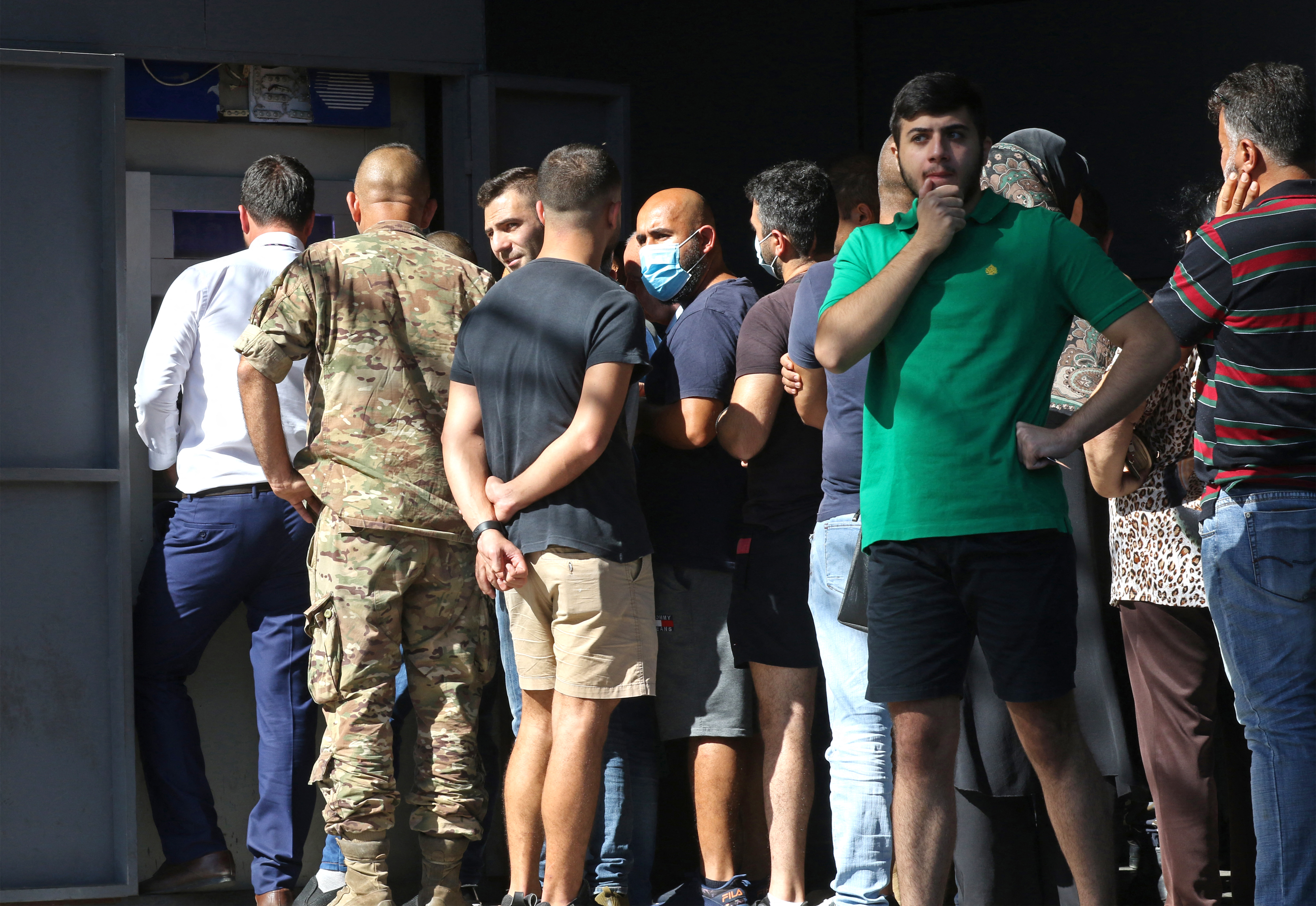 Lebanese depositors queue to withdraw money from an ATM machine outside Fransabank
