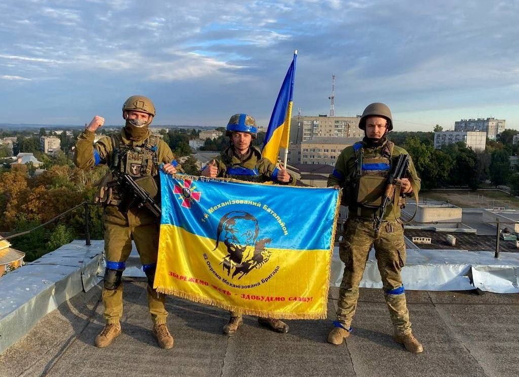 Ukrainian soldiers hold a flag