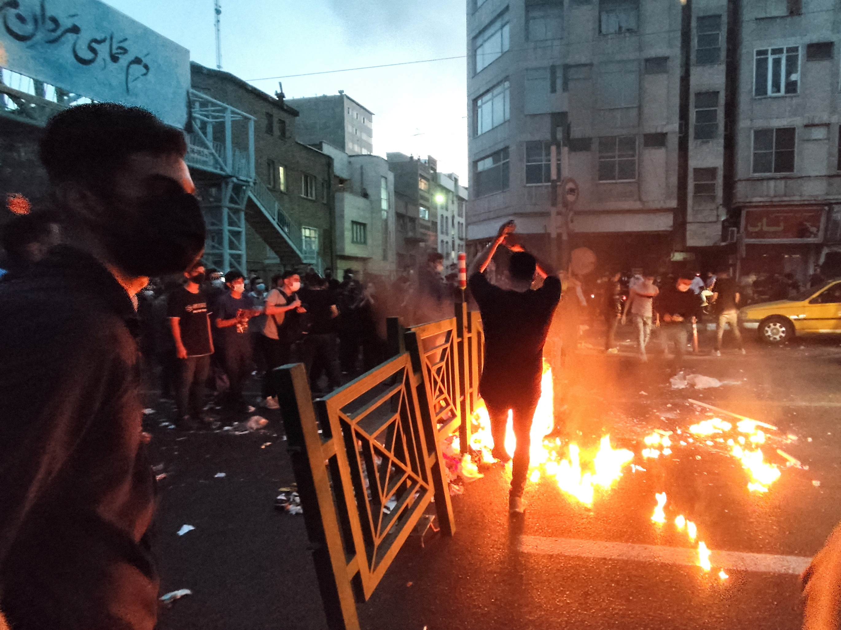 People light a fire during a protest over the death of Mahsa Amini on the streets of Tehran, Iran.