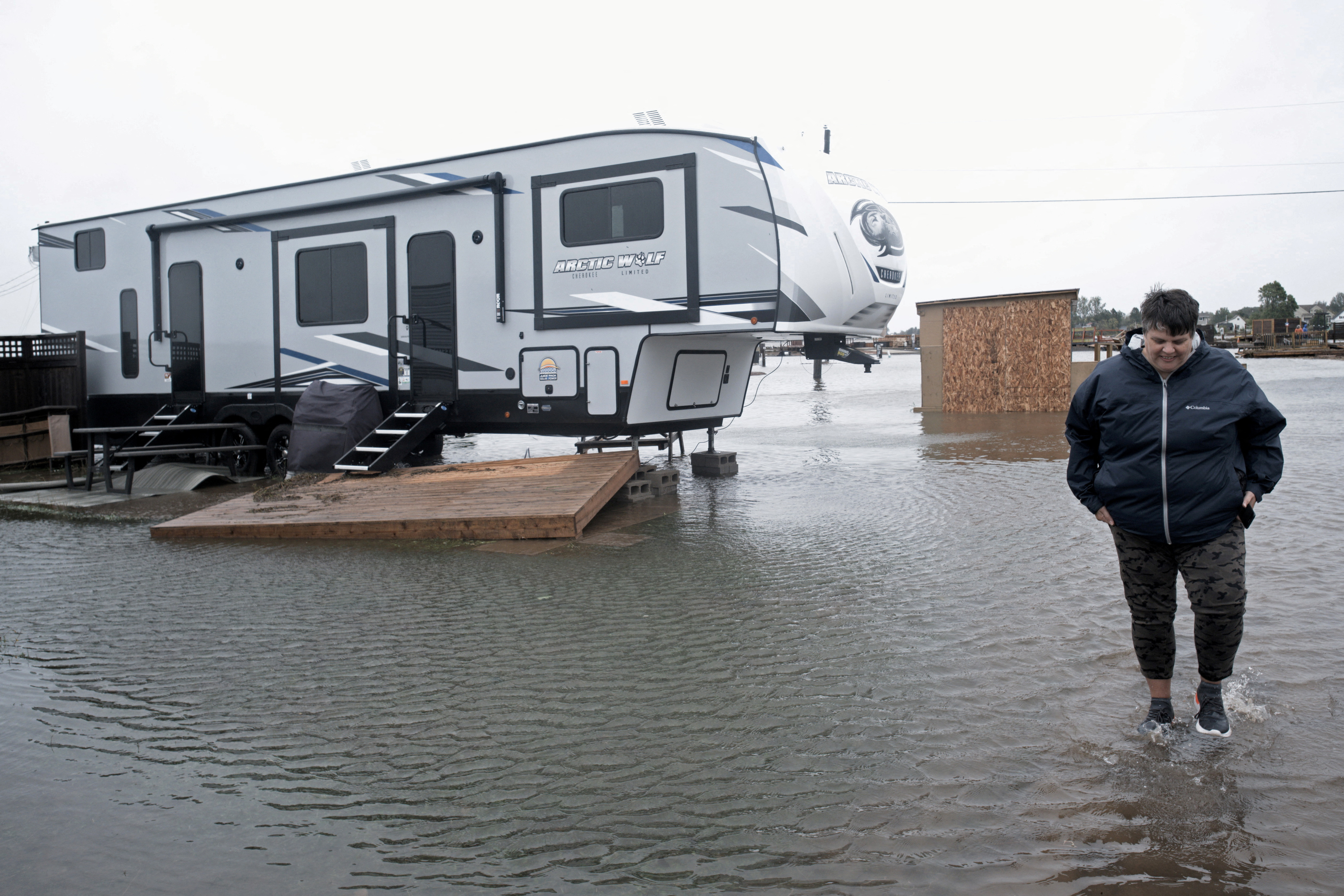 Cathy Simpkins of Moncton walks through flood waters to check her recreational vehicle trailer following the passing of Hurricane Fiona, later downgraded to a post-tropical cyclone, in Shediac, New Brunswick