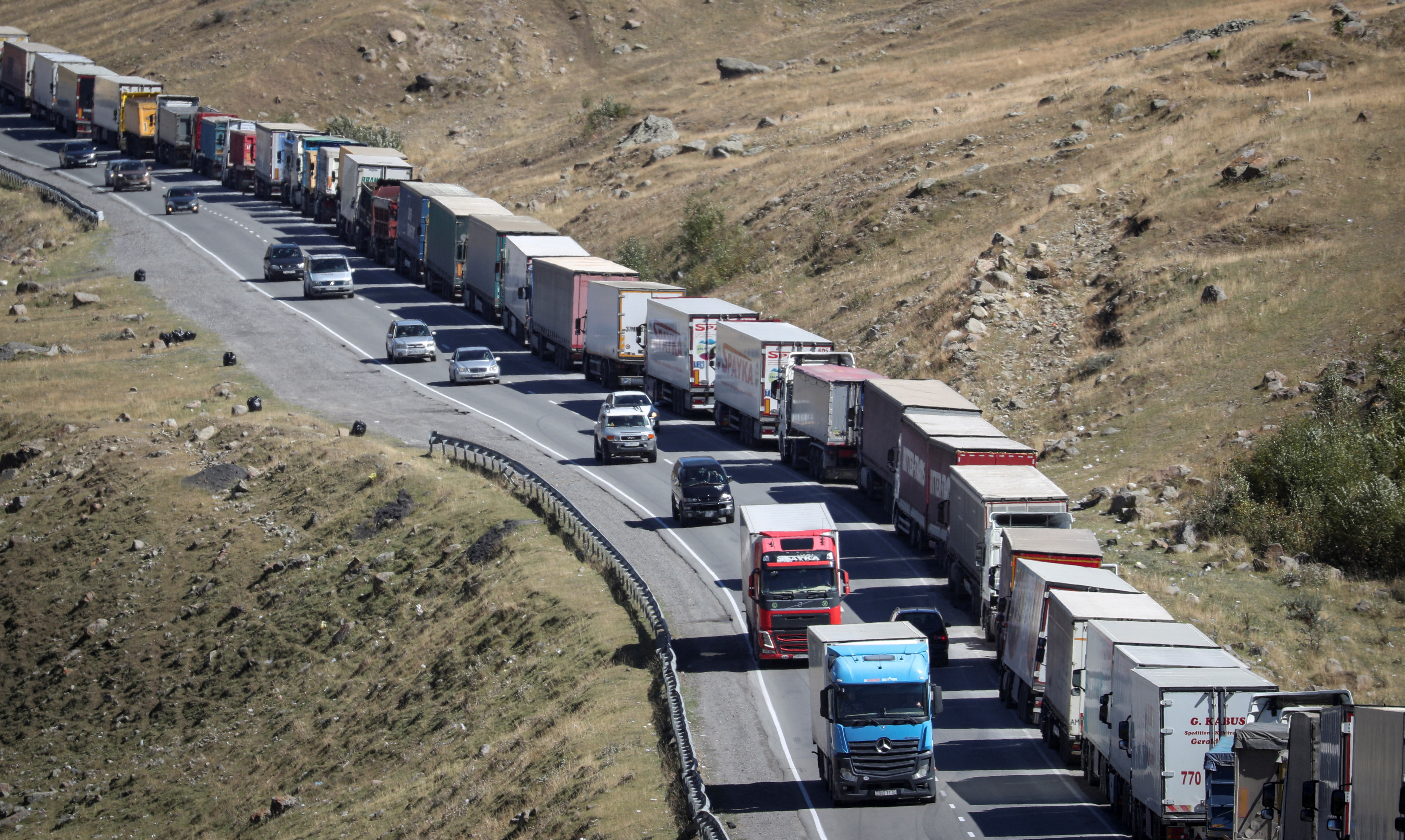 Travellers from Russia drive after crossing the border to Georgia at the at the Zemo Larsi/Verkhny Lars station
