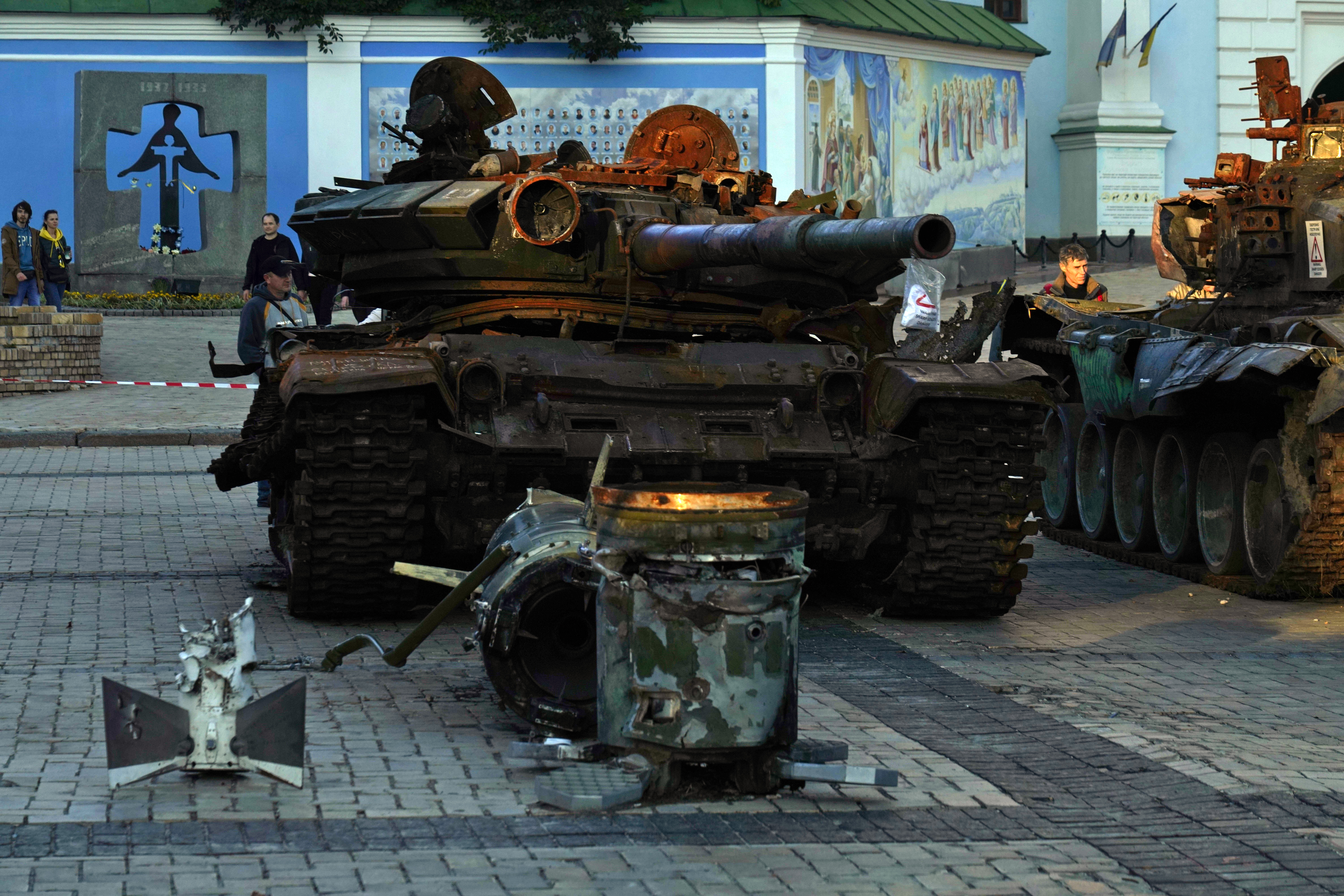 A man stands as the sun sets near a display of destroyed Russian tanks and armored vehicles near St. Michael's Golden-Domed Monastery in Kyiv, Ukraine, Sunday, Sept. 11, 2022. (AP Photo/Jon Gambrell)