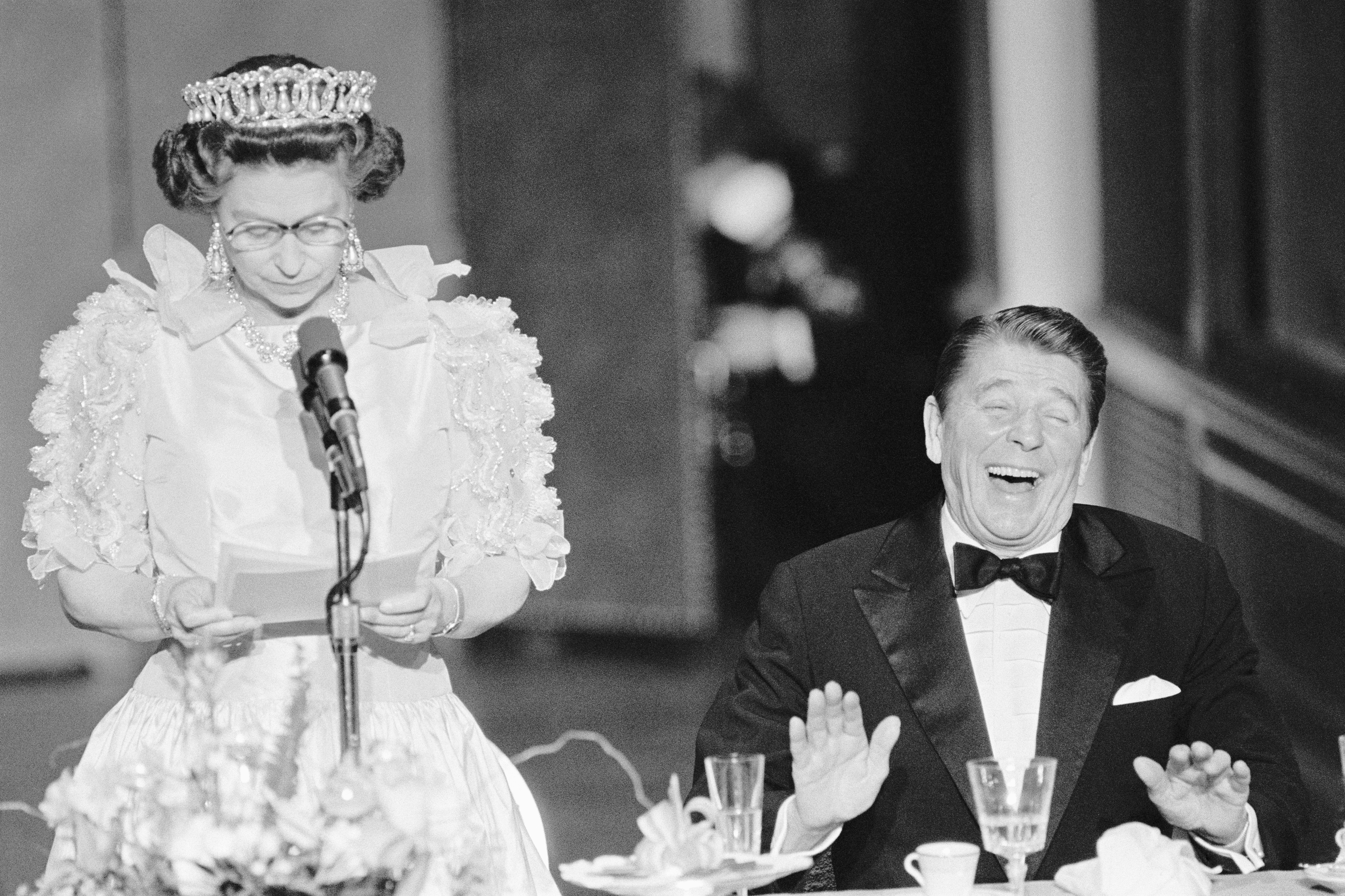 US President Ronald Reagan laughs following a joke by Queen Elizabeth II, who commented on the California weather she has experienced since she arrived in the US