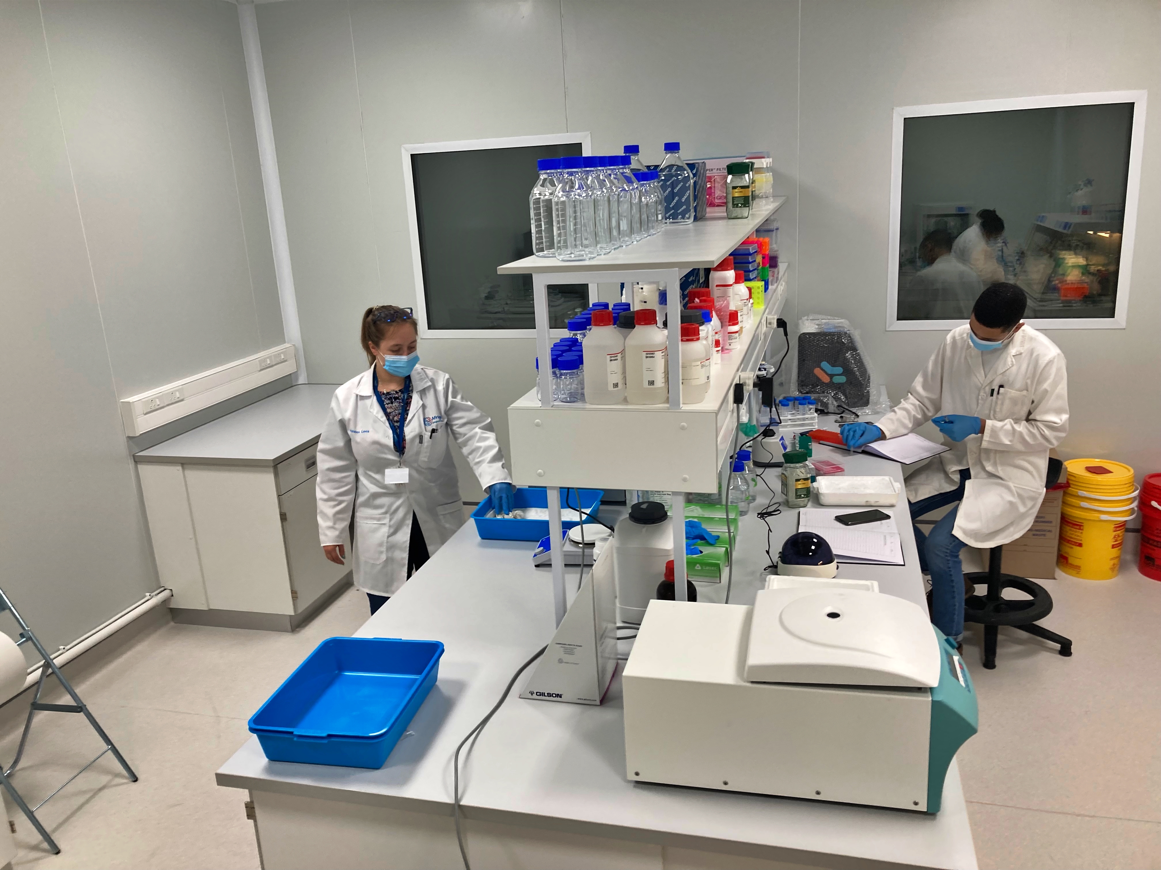 Two research technicians work in a lab