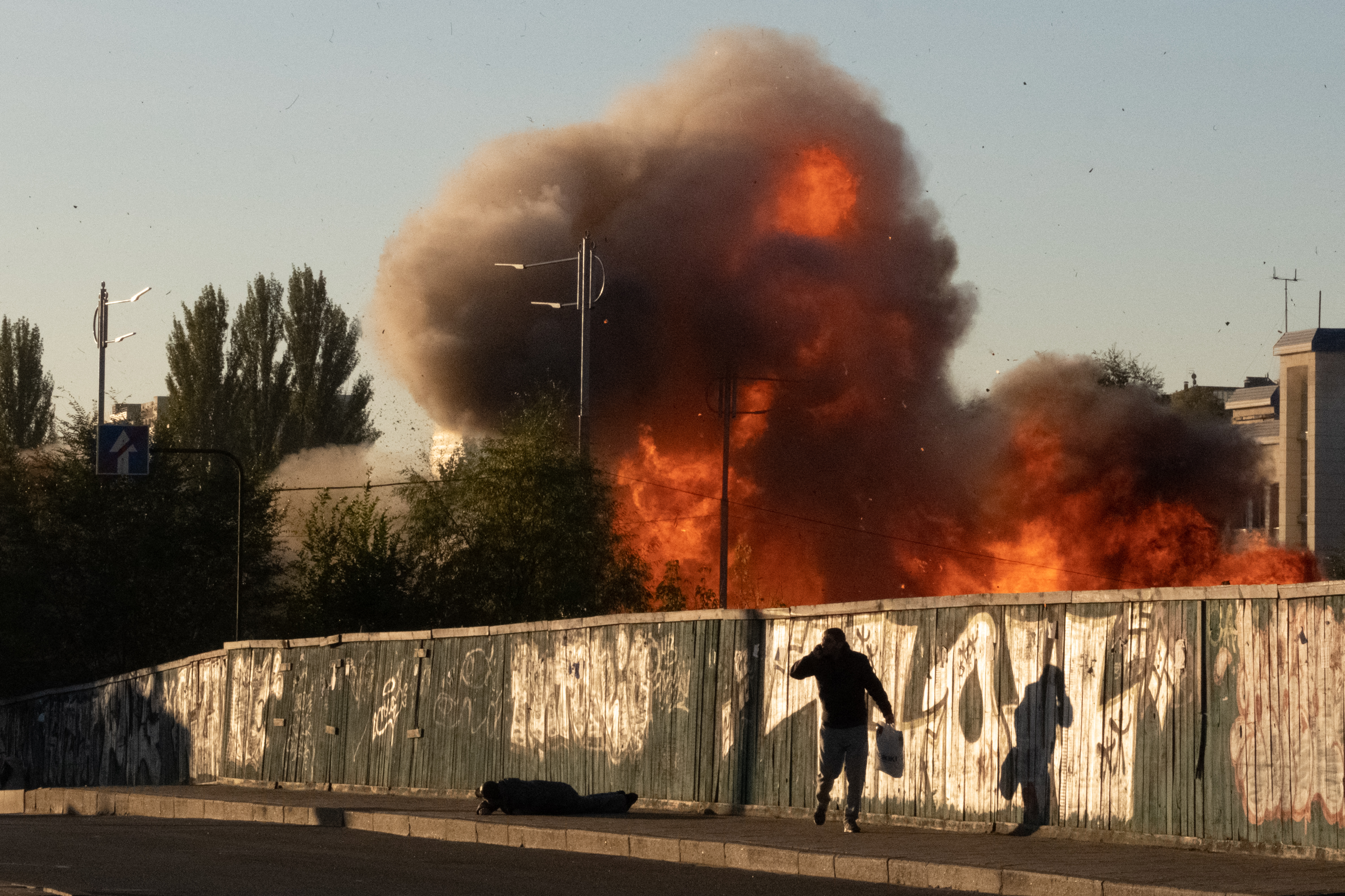 A man falls on the ground following a drone attack in Kyiv.