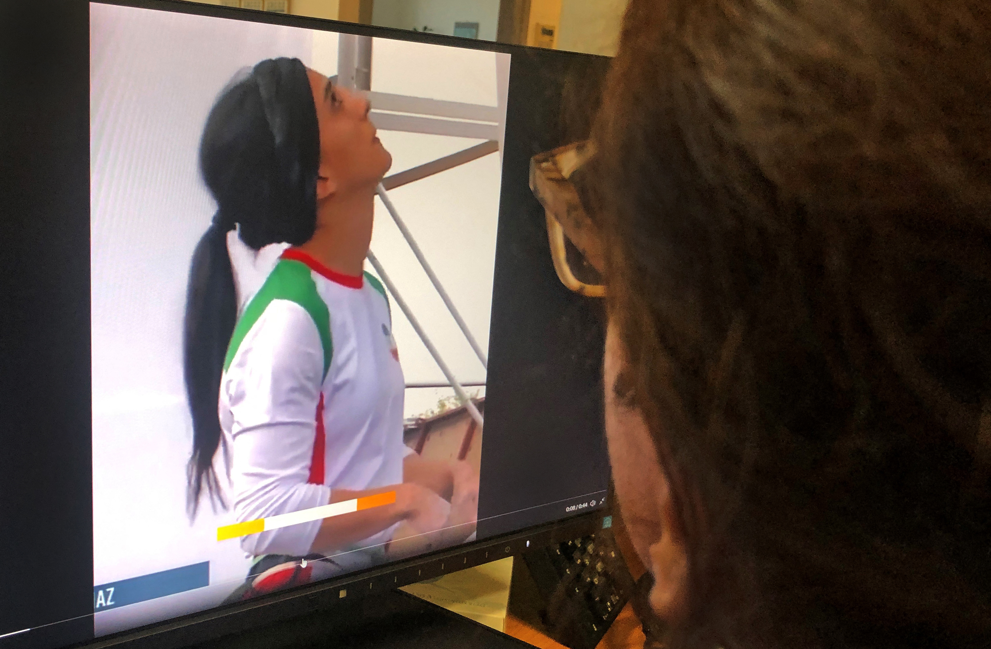 A woman looks at a screen displaying a video of an international climbing competition is Seoul, South Korea