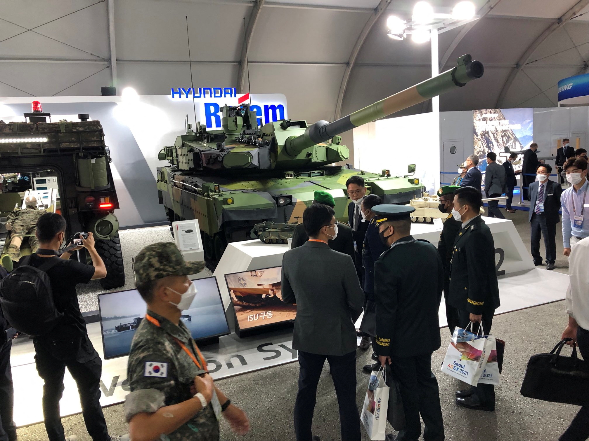 A K2 Black Panther tank painted in green camouflage colours, on display with officials standing around
