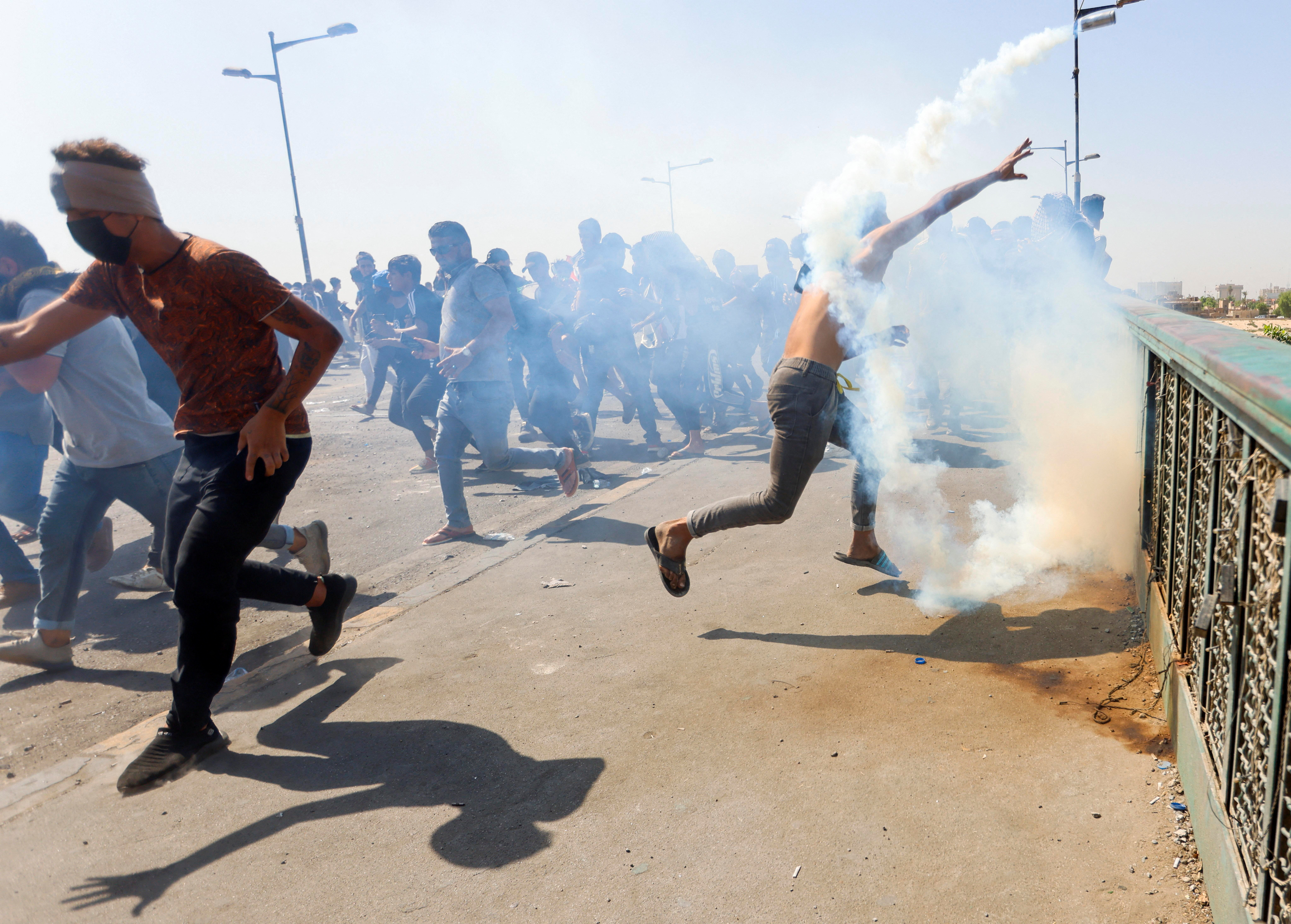 An Iraqi protester hurls a tear gas canister during clashes with security forces at a gathering to mark the third anniversary of the anti-government protests in Baghdad, Iraq October 1, 2022. REUTERS/Ahmed Saad