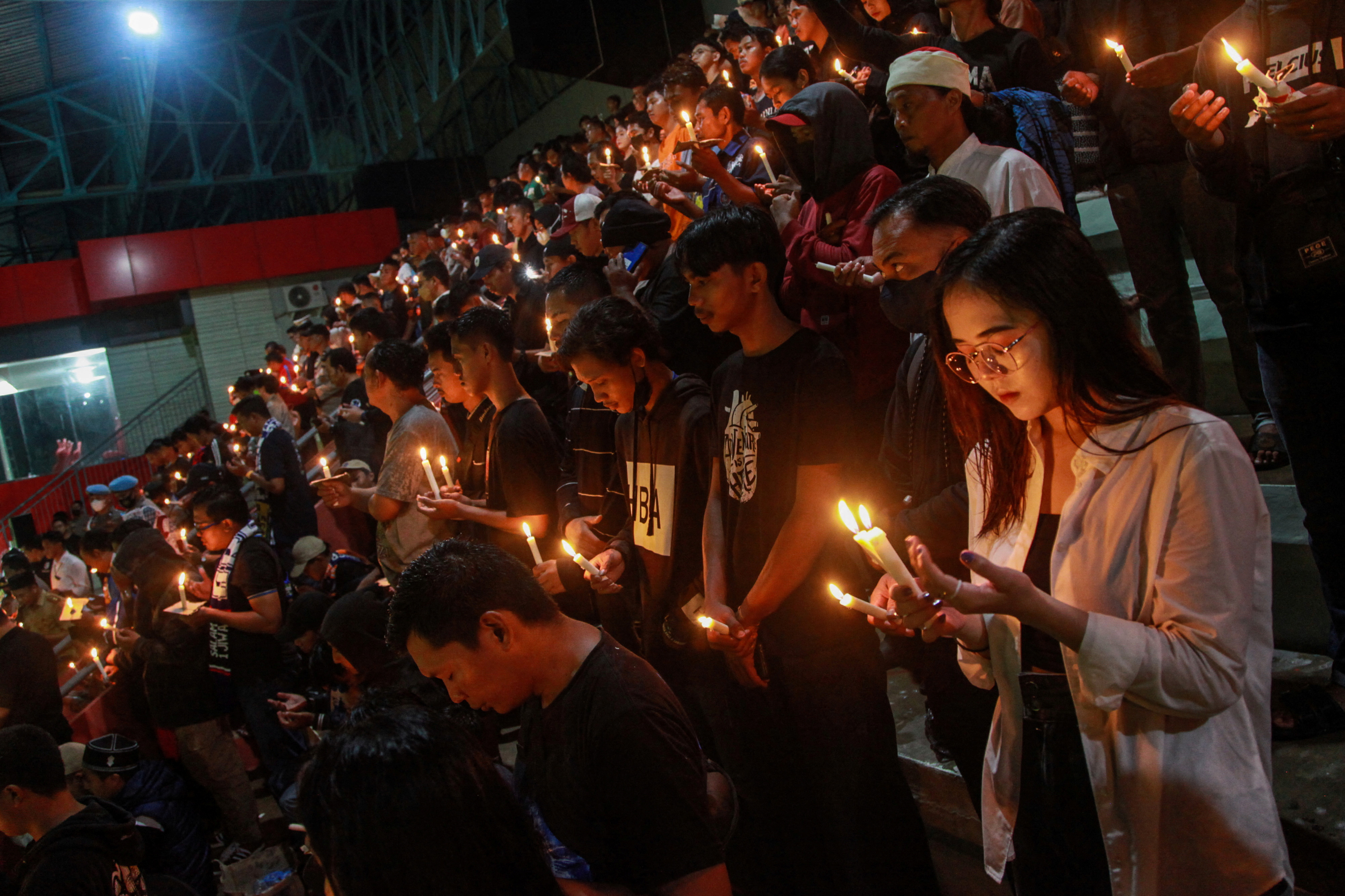 Football club supporters pray during a vigil at Toah Pahoe Stadium, after a riot and stampede at Kanjuruhan Stadium following a soccer match between Arema vs Persebaya Surabaya, in Palangka Raya, Central Kalimantan province, Indonesia, October 3, 2022.