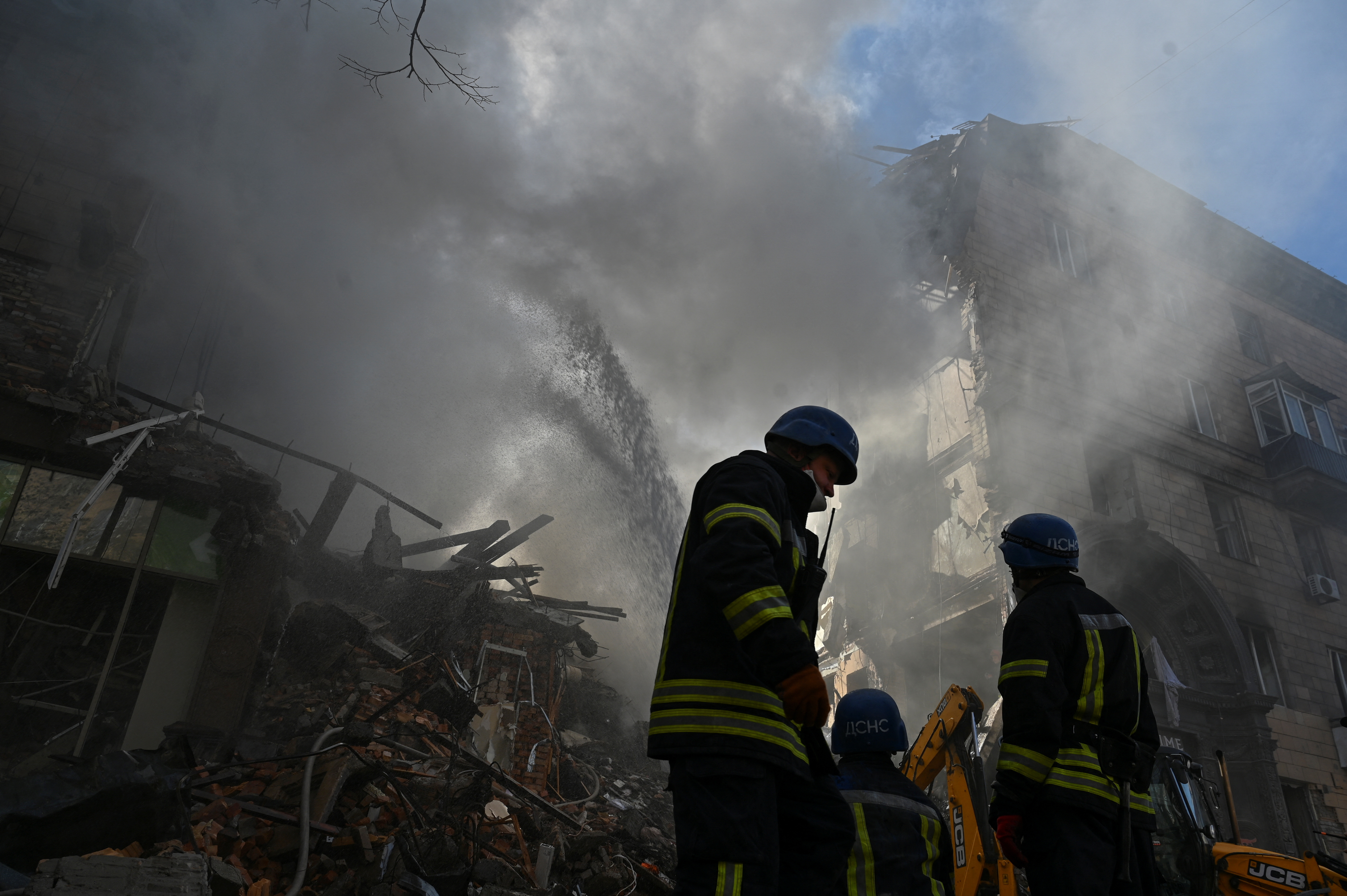 Rescue teams work at a residential building in Zaporizhzhia damaged in a Russian bombing