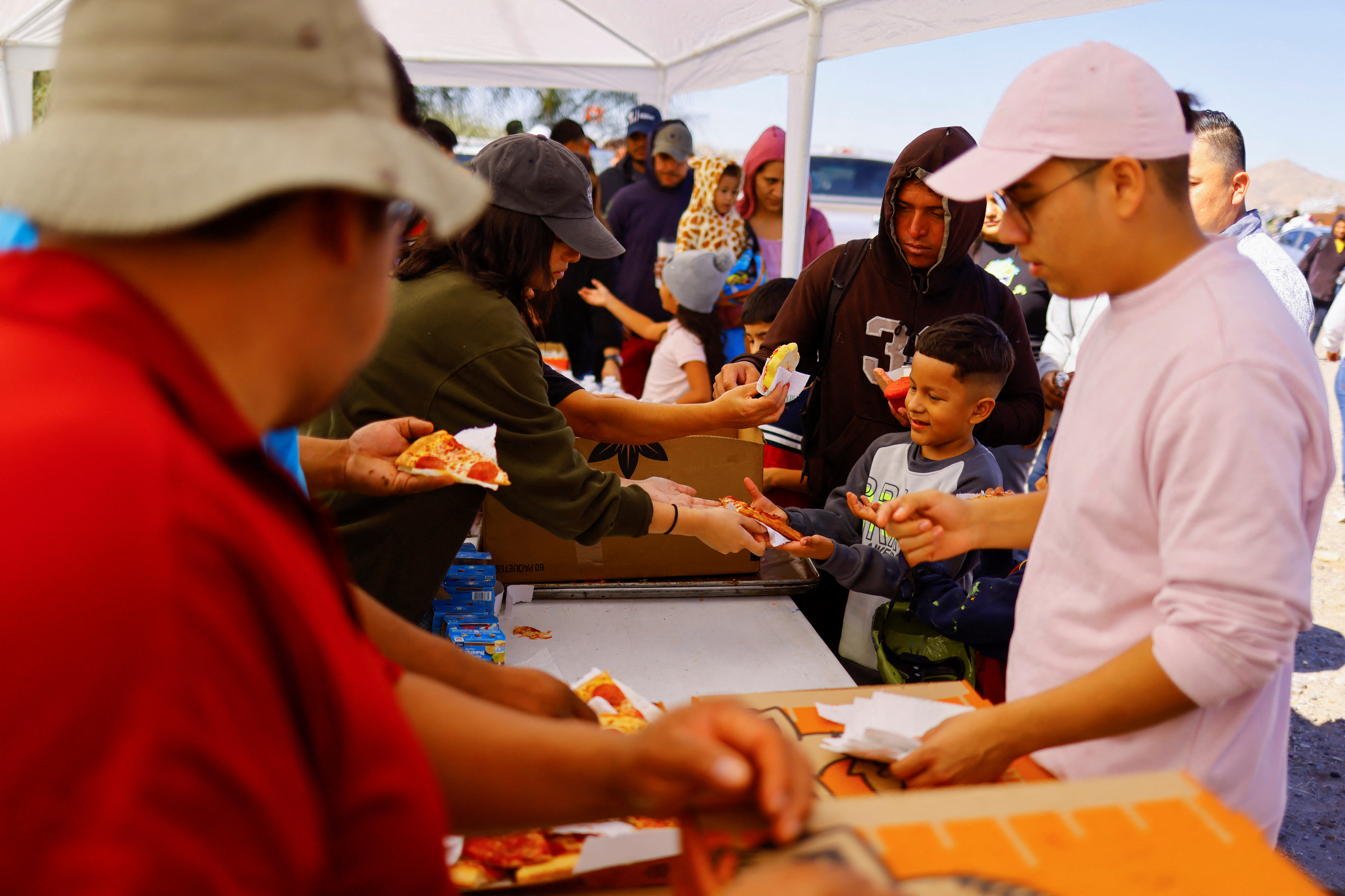 Migrants and asylum seekers wait in line for food in Mexico
