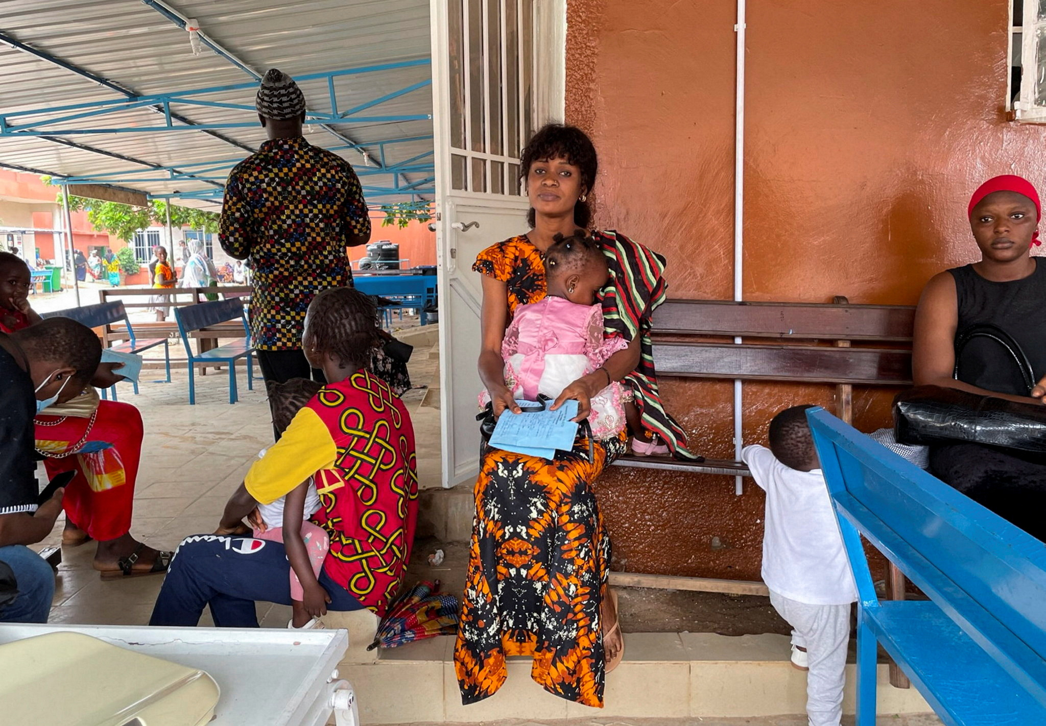 A woman waits at a hospital in The Gambia