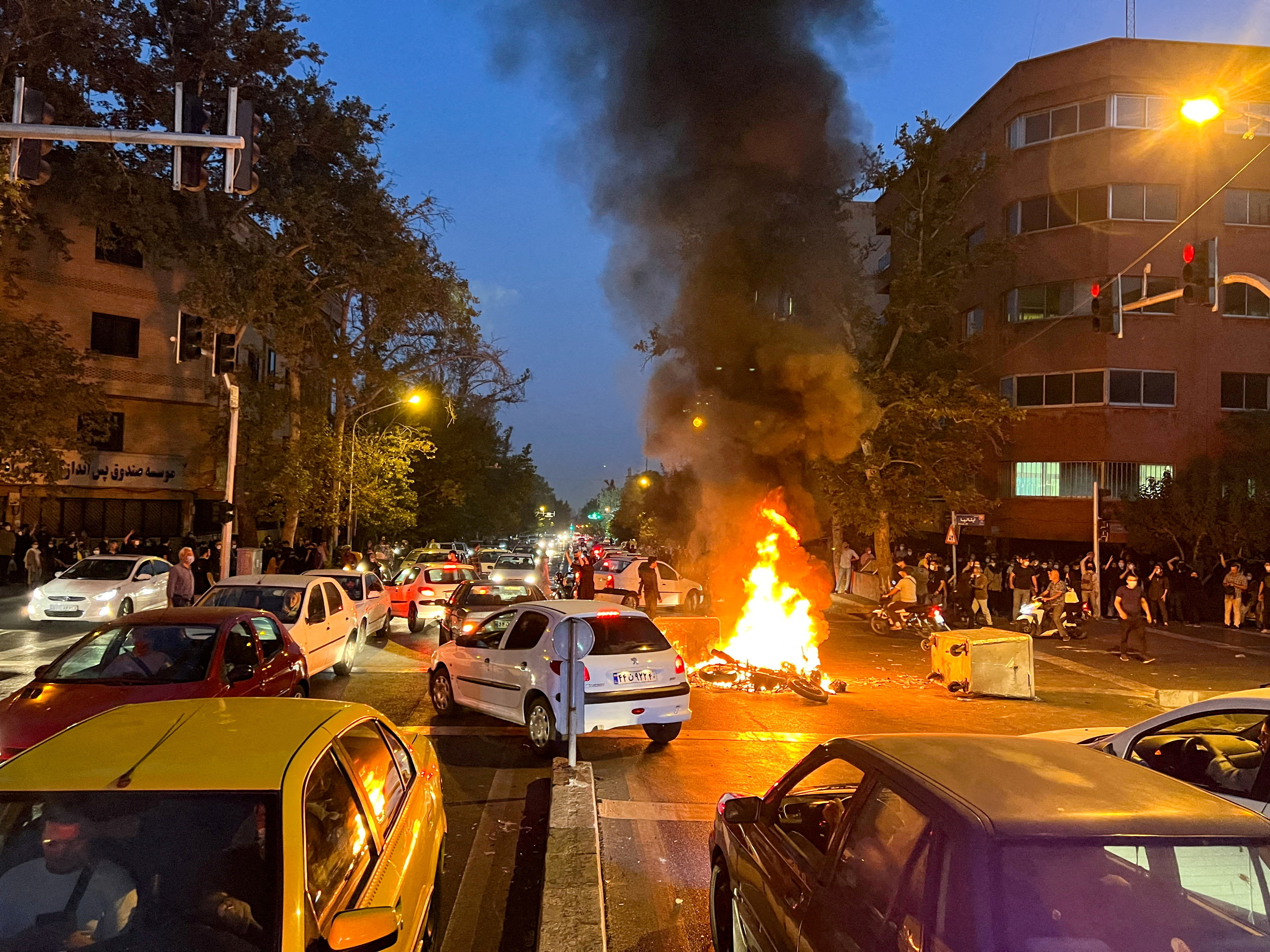 A police motorcycle burns during a protest over the death of Mahsa Amini, a woman who died after being arrested by the Islamic republic's "morality police", in Tehran, Iran September 19, 2022.