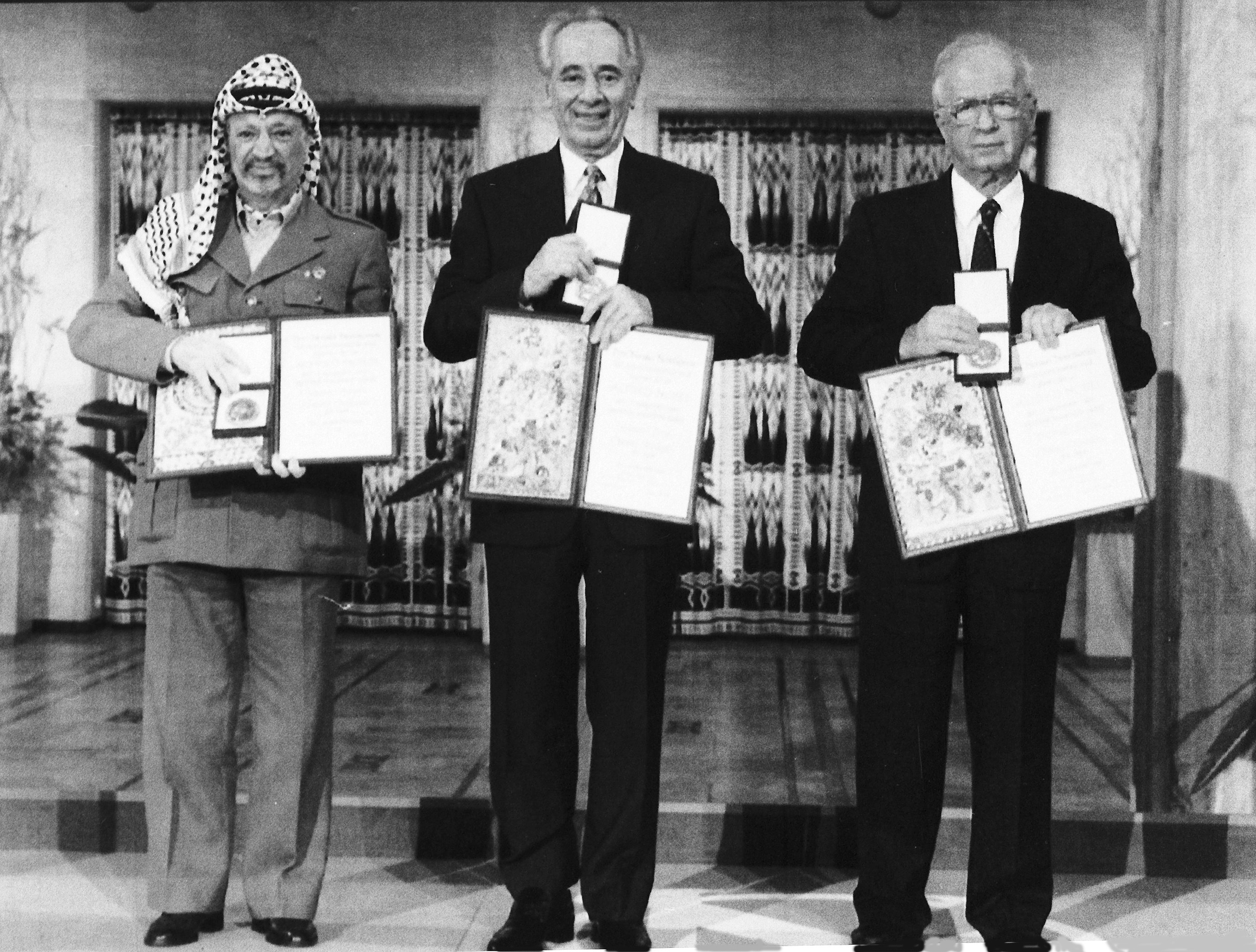 PLO leader Yasser Arafat, Israeli Prime Minister Yitzhak Rabin and Israeli Foreign Minister Shimon Peres pose with their medals and diplomas, after receiving the 1994 Nobel Peace Prize in Oslo