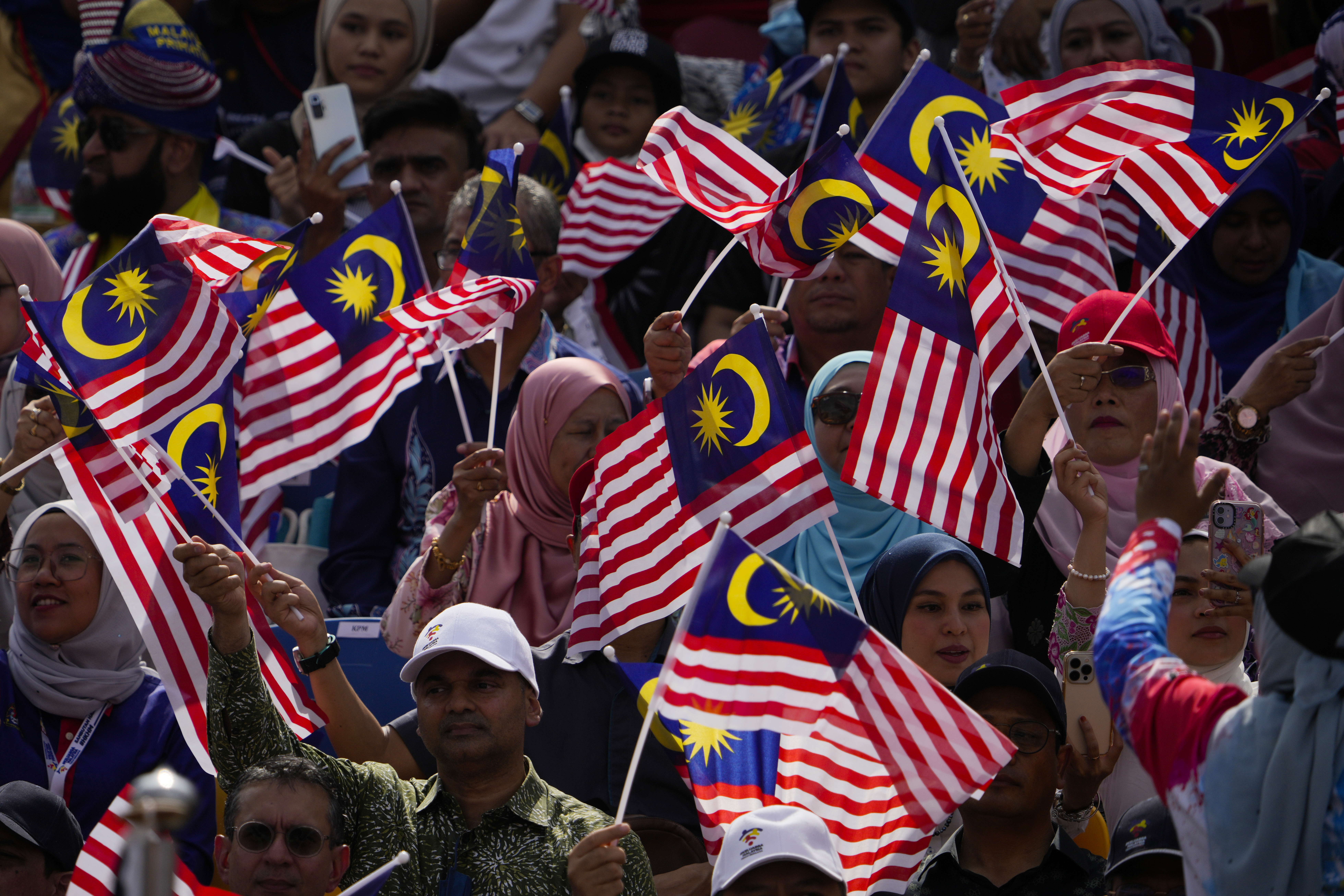 Malaysians waving the national flag during independence day celebrations