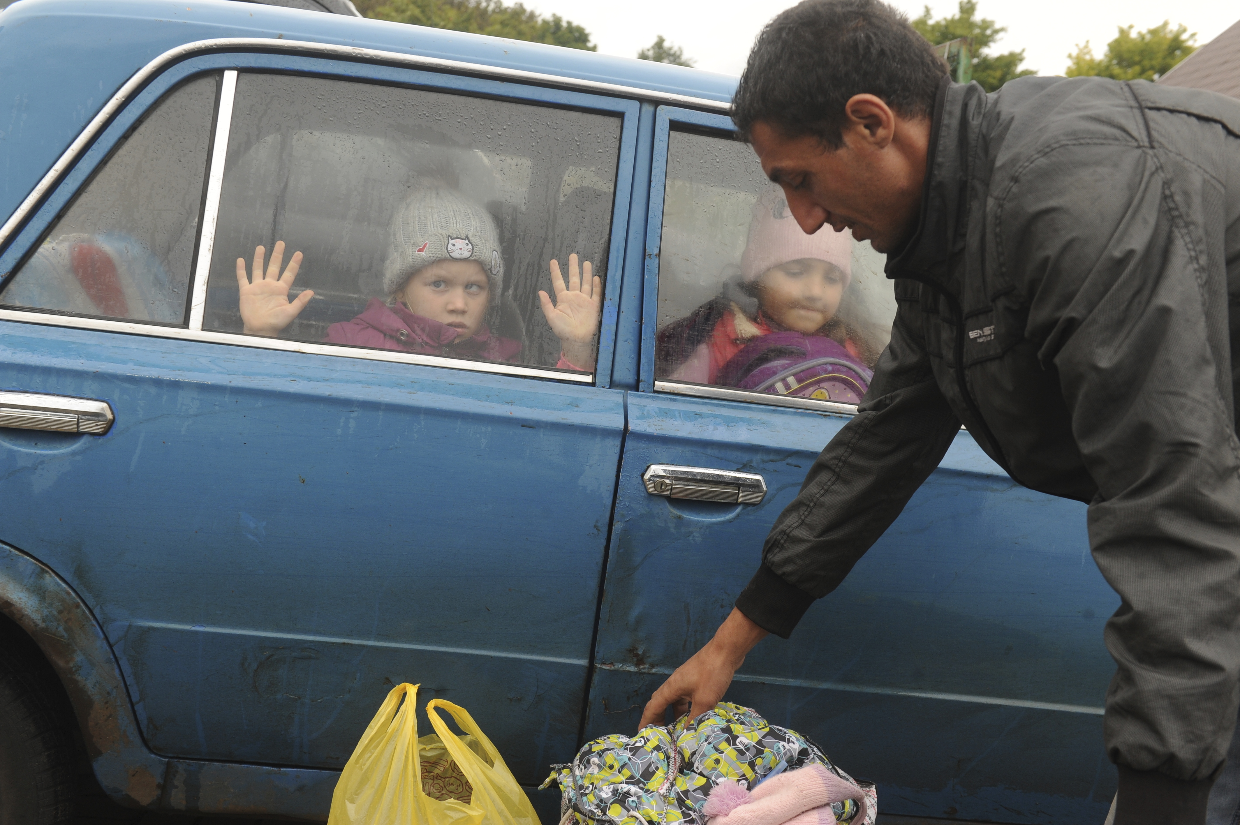 Children look through a car’s windows as they and other refugees from the Kharkiv region of Ukraine arrive at a temporary camp in Belgorod, Russia