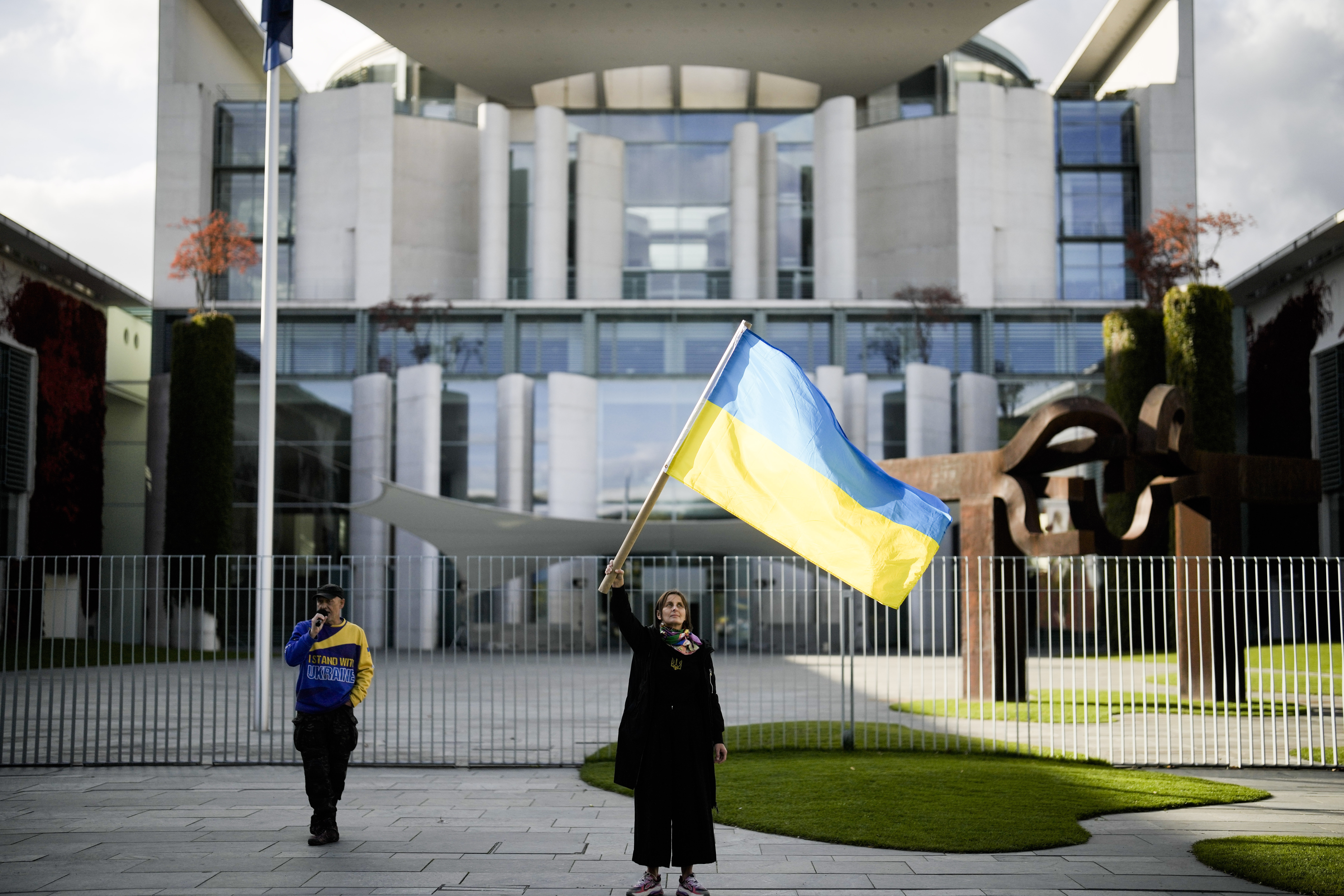 A woman waves a Ukrainian flag as she attends a protest against the war in Ukraine in front of the chancellery in Berlin, Germany, October 11, 2022