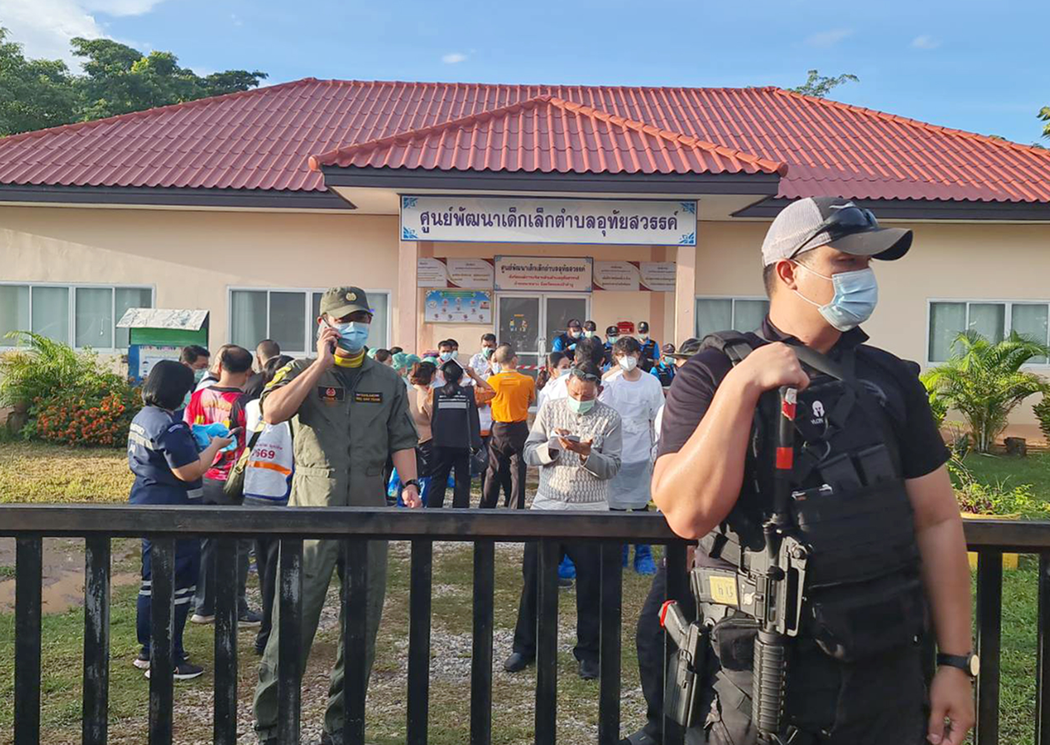 Armed police officer standing guard as relatives of the victims of a mass shooting gather at a childcare center in Nong Bua Lamphu province, northeastern Thailand