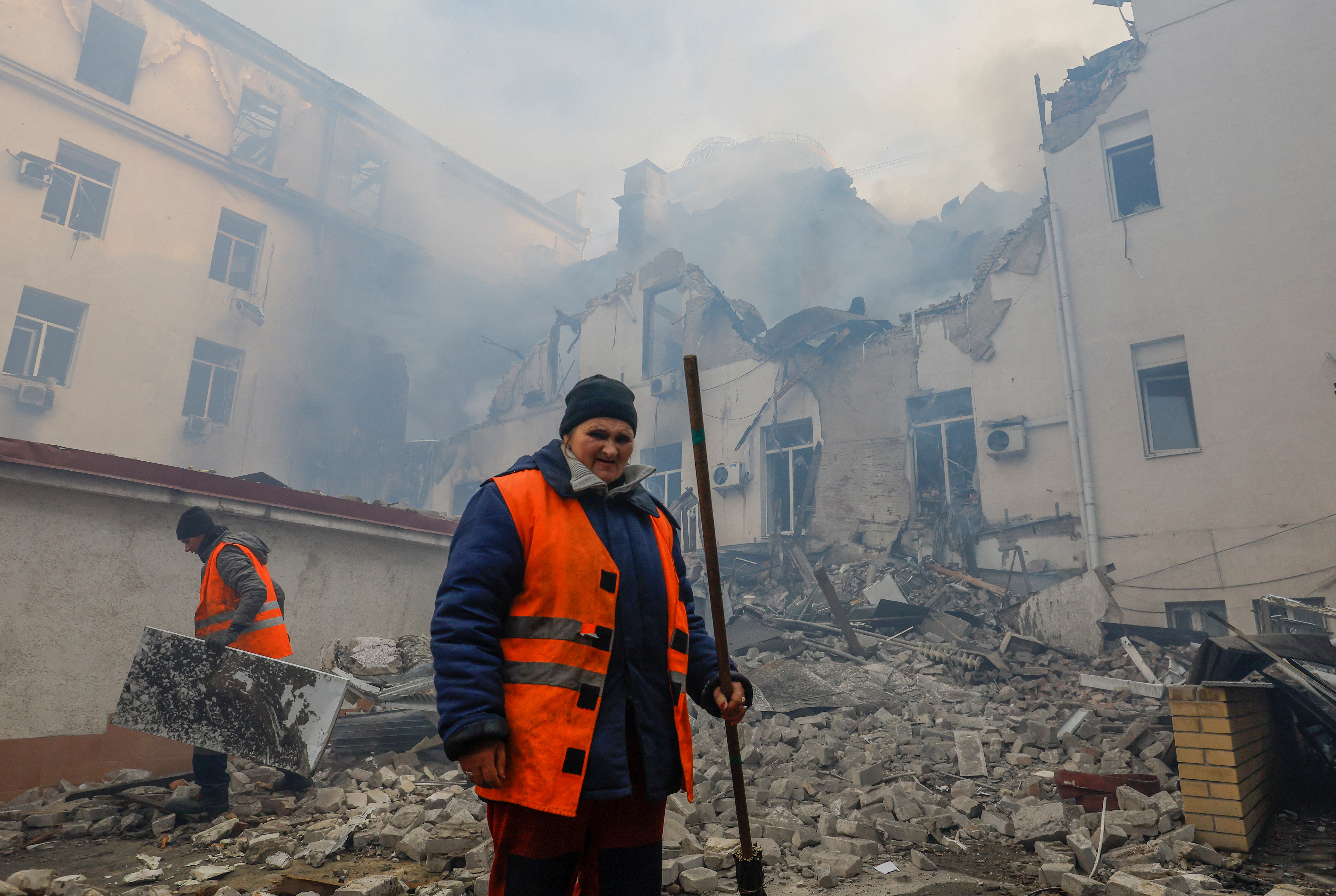 Municipal workers remove debris outside a railway administration headquarters damaged in shelling in Donetsk, Ukraine