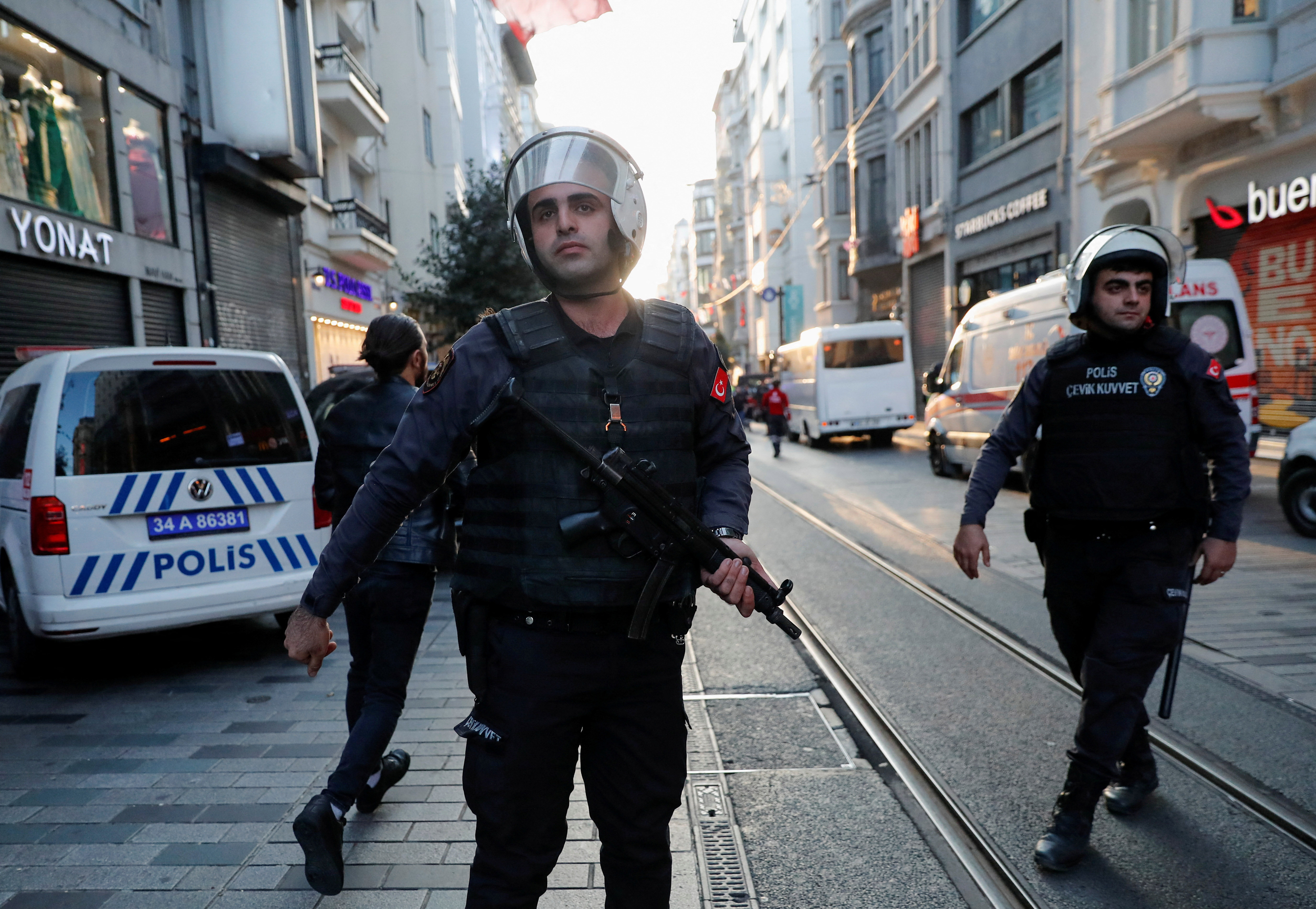 Police officers stand near the scene after an explosion on busy pedestrian Istiklal street in Istanbul.