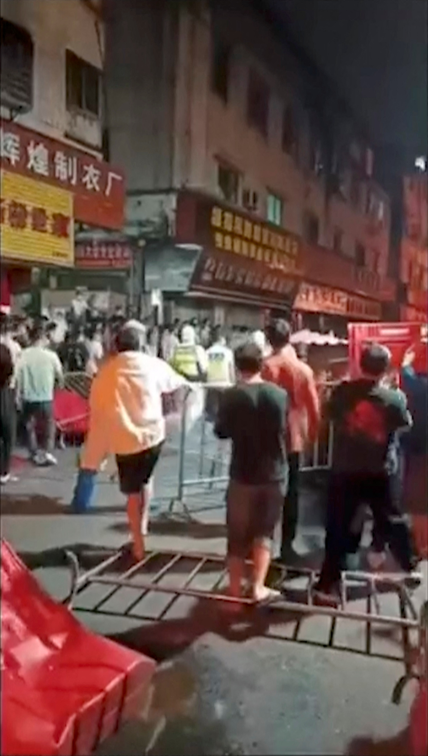 Crowds on the street amid fallen barriers in Guangzhou
