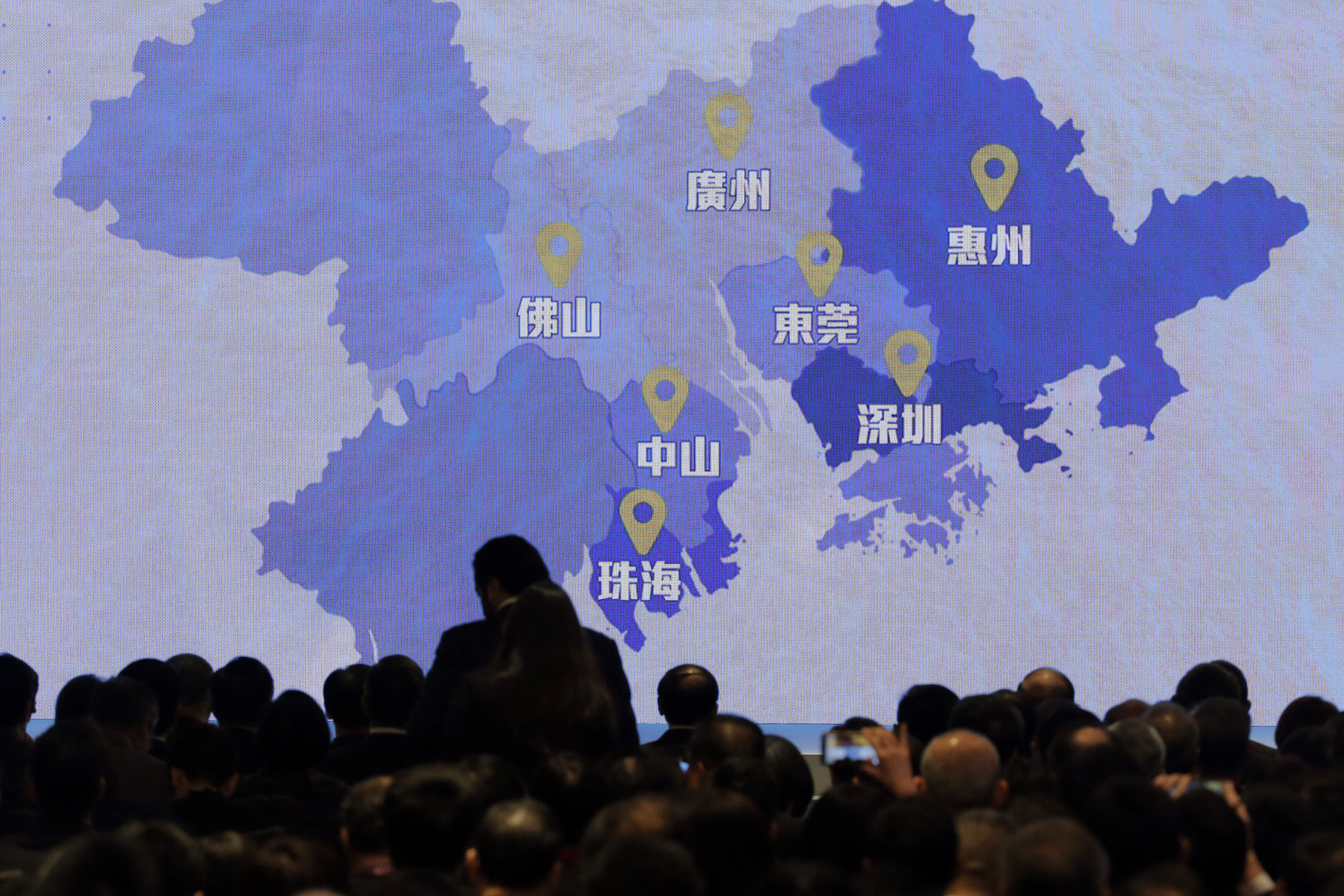 Map on a big screen showing the Great Bay Area to an assembled crowd.