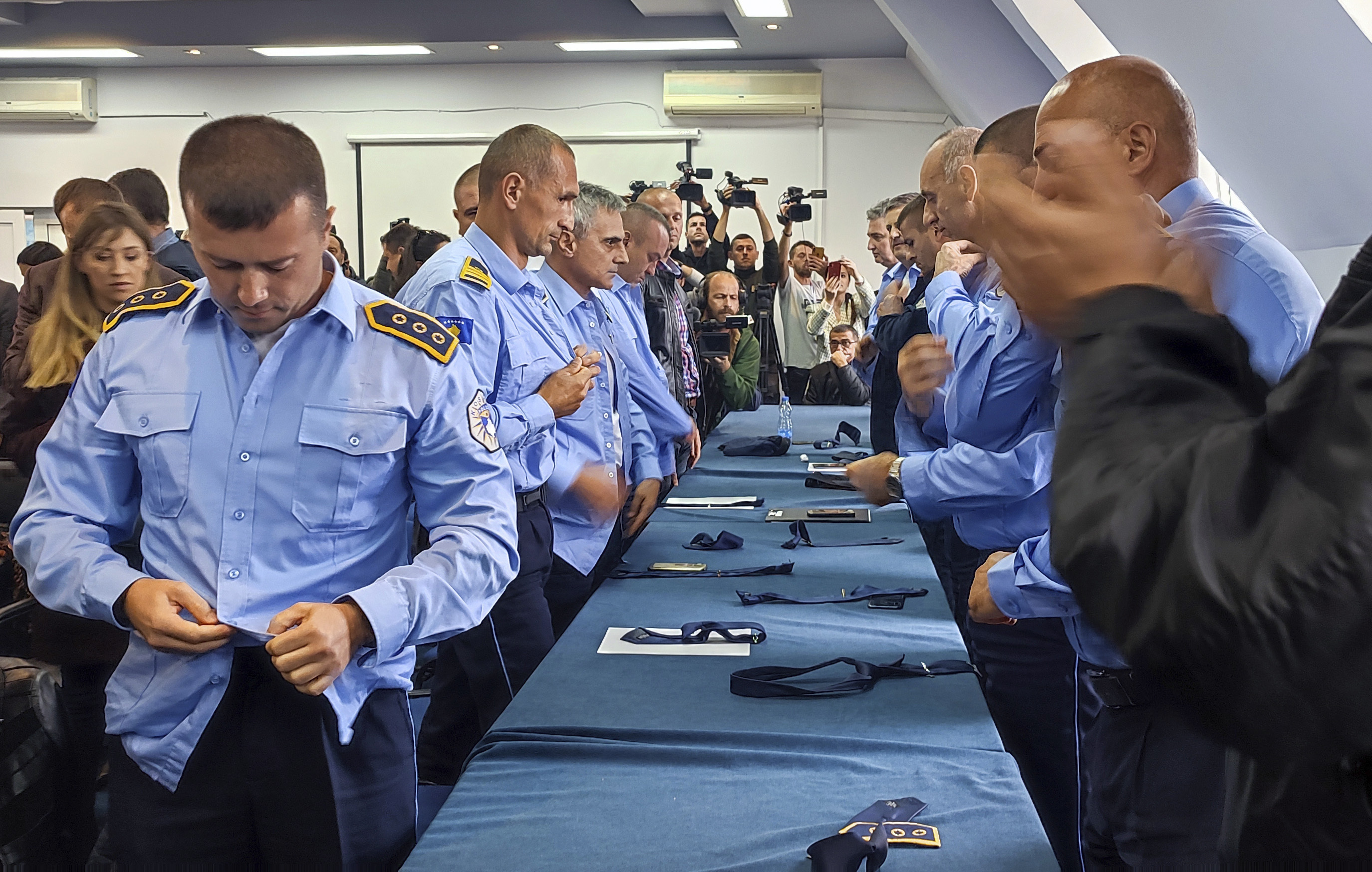Police officers remove their uniforms in the town of Zvecan, Kosovo, in November 2022 as members of Kosovo’s ethnic Serb minority resigned en masse from their posts to protest the dismissal of a senior Serb police officer who did not respect the Kosovo government’s decision to change vehicle license plates