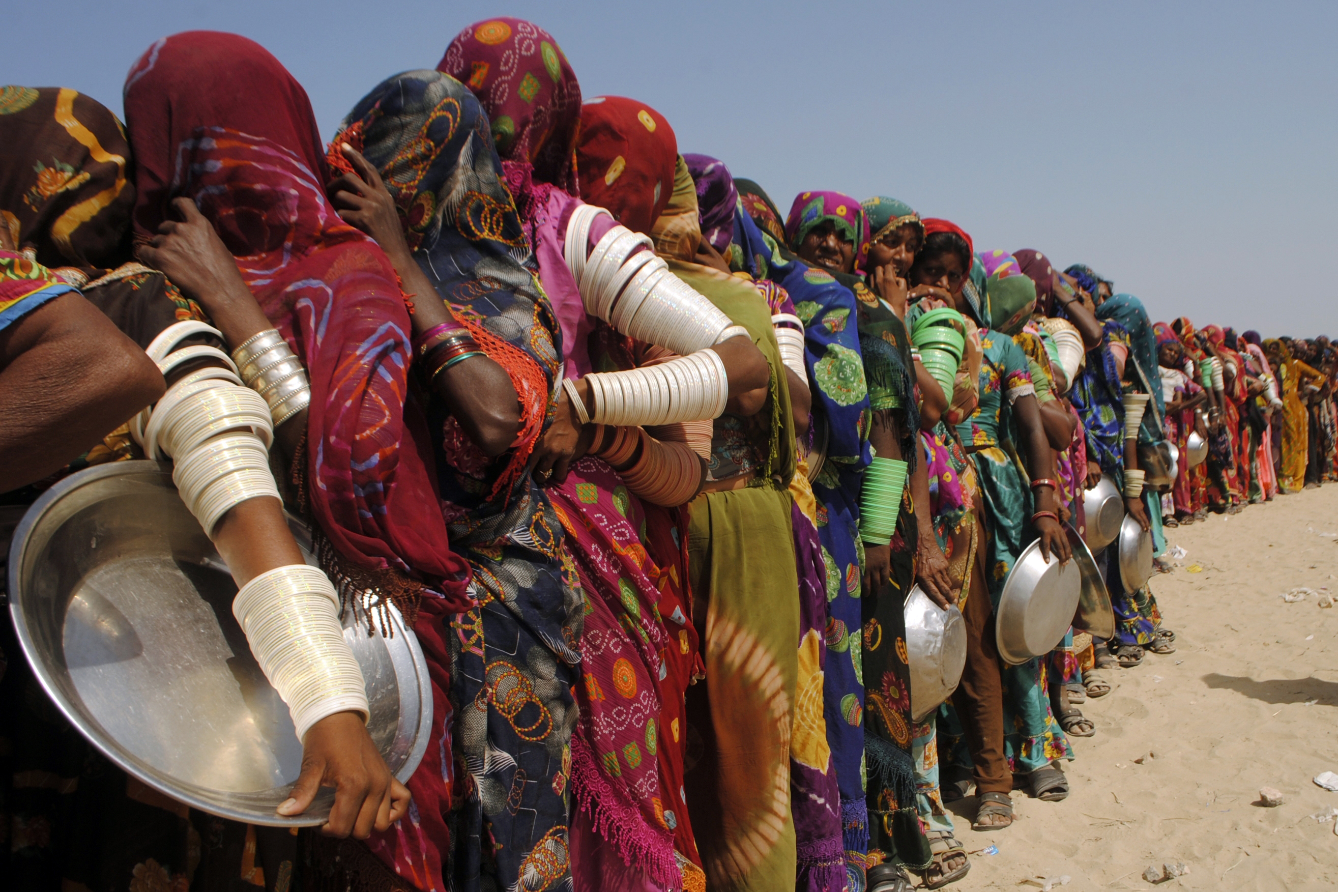 Women from flood-affected areas wait to get free food distributed by a charity, in Chachro, near Tharparkar, a district of southern Sindh province, Pakistan, September 19, 2022