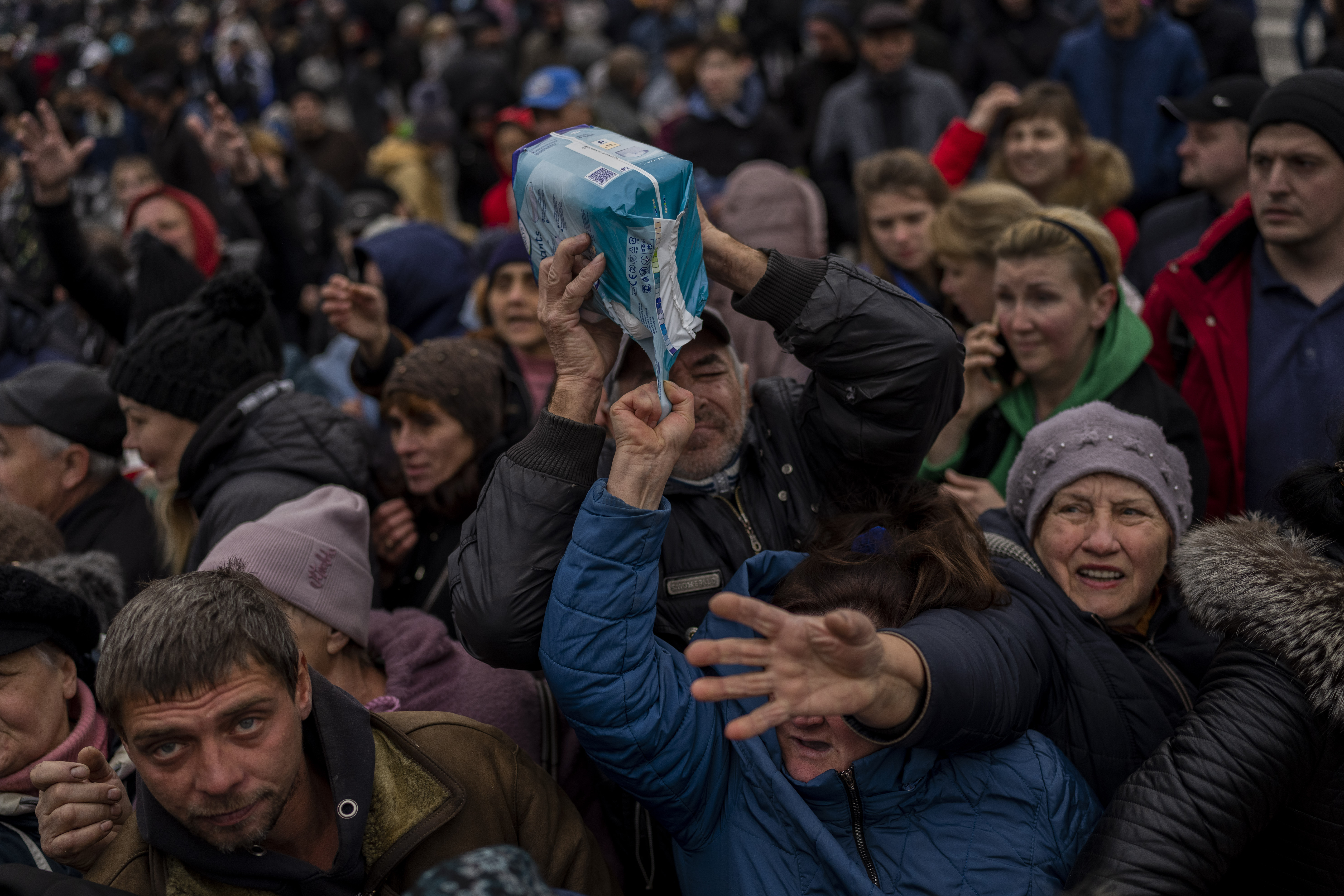 Residents gathering at an aid distribution point receive supplies in downtown Kherson, southern Ukraine, Friday, November 18, 2022