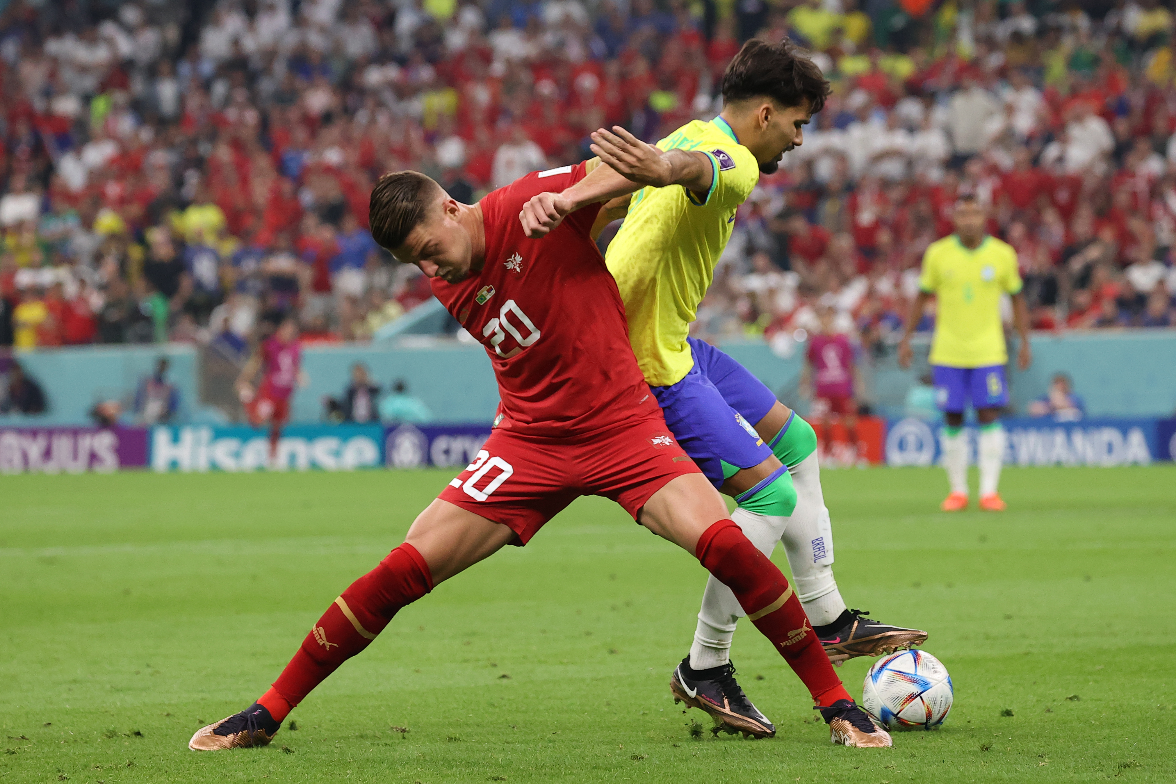 A Serbian player [front] tackles a Brazilian during their Group G FIFA World Cup game at Lusail Stadium on November 24, 2022