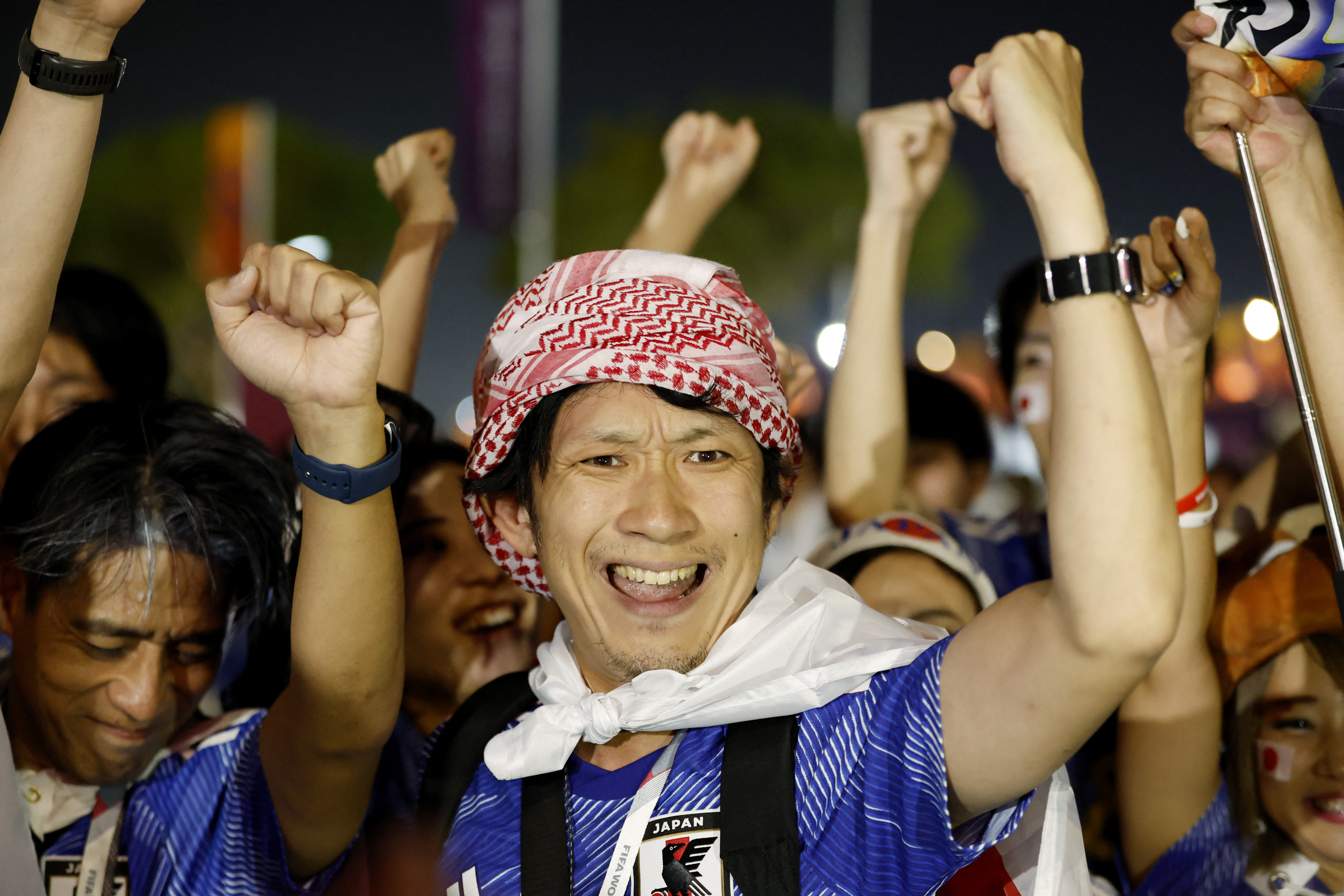 Japan fans celebrate outside the stadium after their match against Spain that saw the Japanese side qualify for the knockout stages of the World Cup tournament