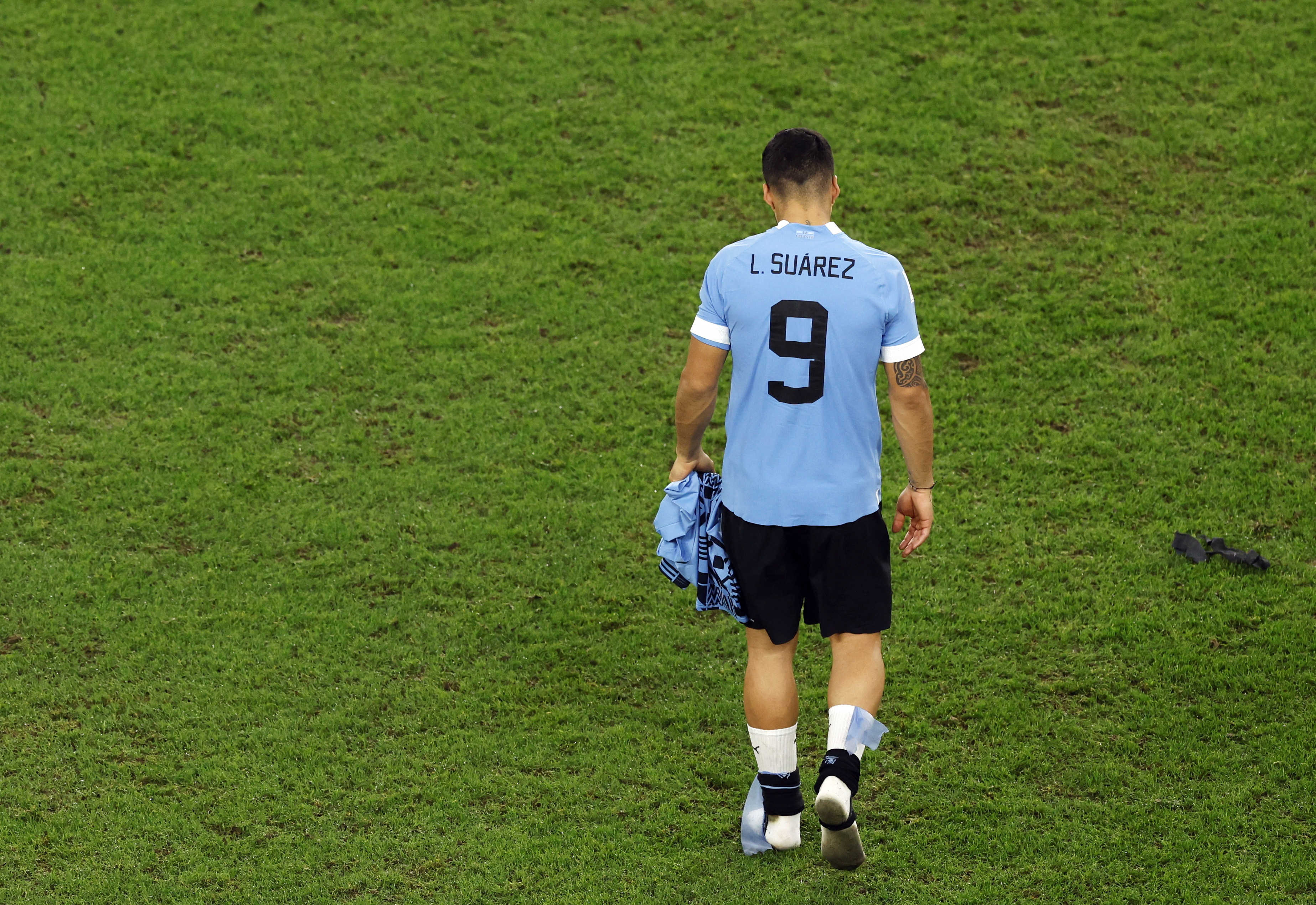 Luis Suarez from the back, walking along the pitch with his head down