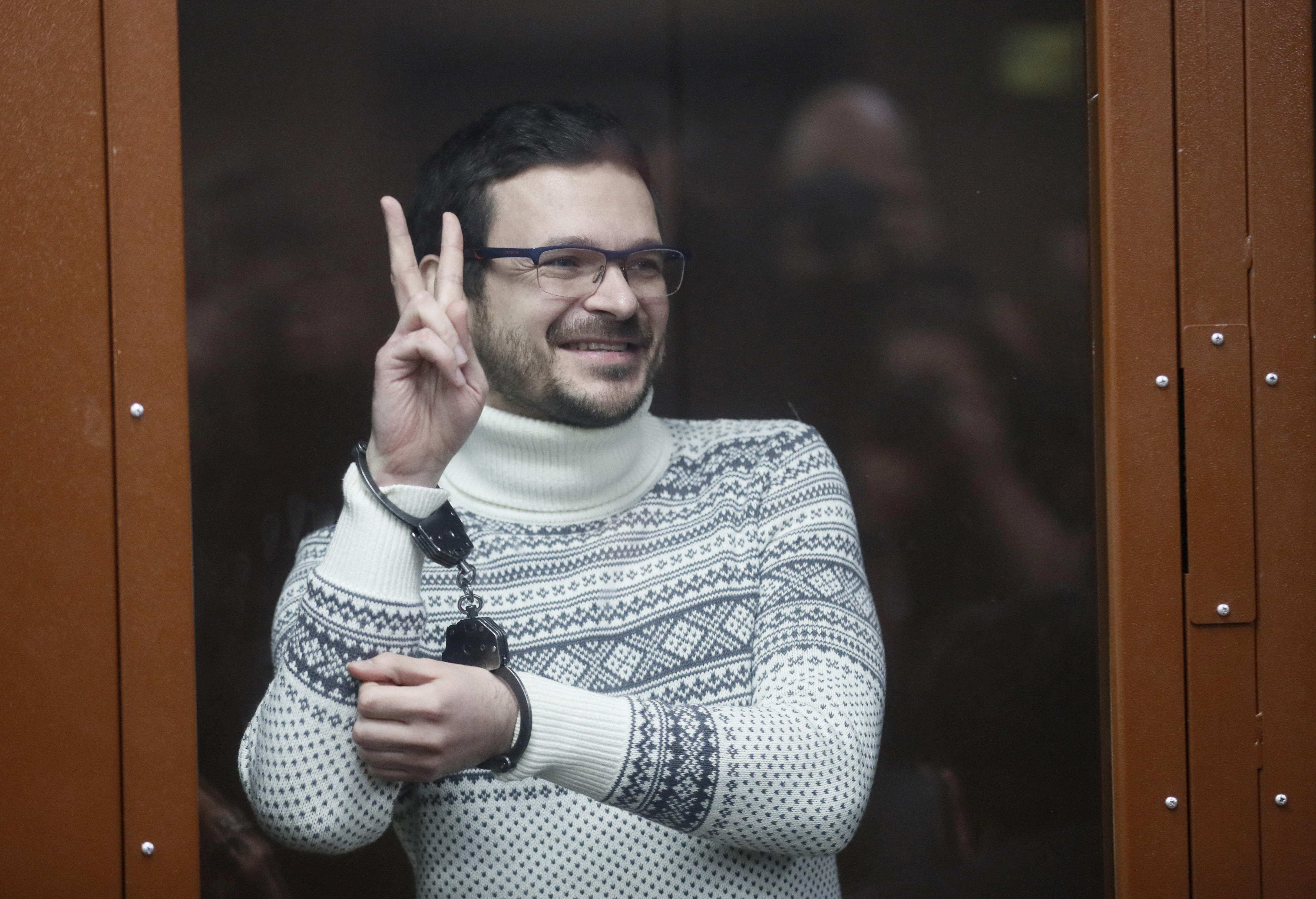 Russian opposition leader, former Moscow's municipal deputy Ilya Yashin gestures in a defendants' glass cage prior to a verdict hearing at the Meshchansky district court in Moscow, Russia, December 9, 2022. Prosecution requested nine years in prison for Yashin for spreading fake information about the Russian army. Yuri Kochetkov/Pool via REUTERS