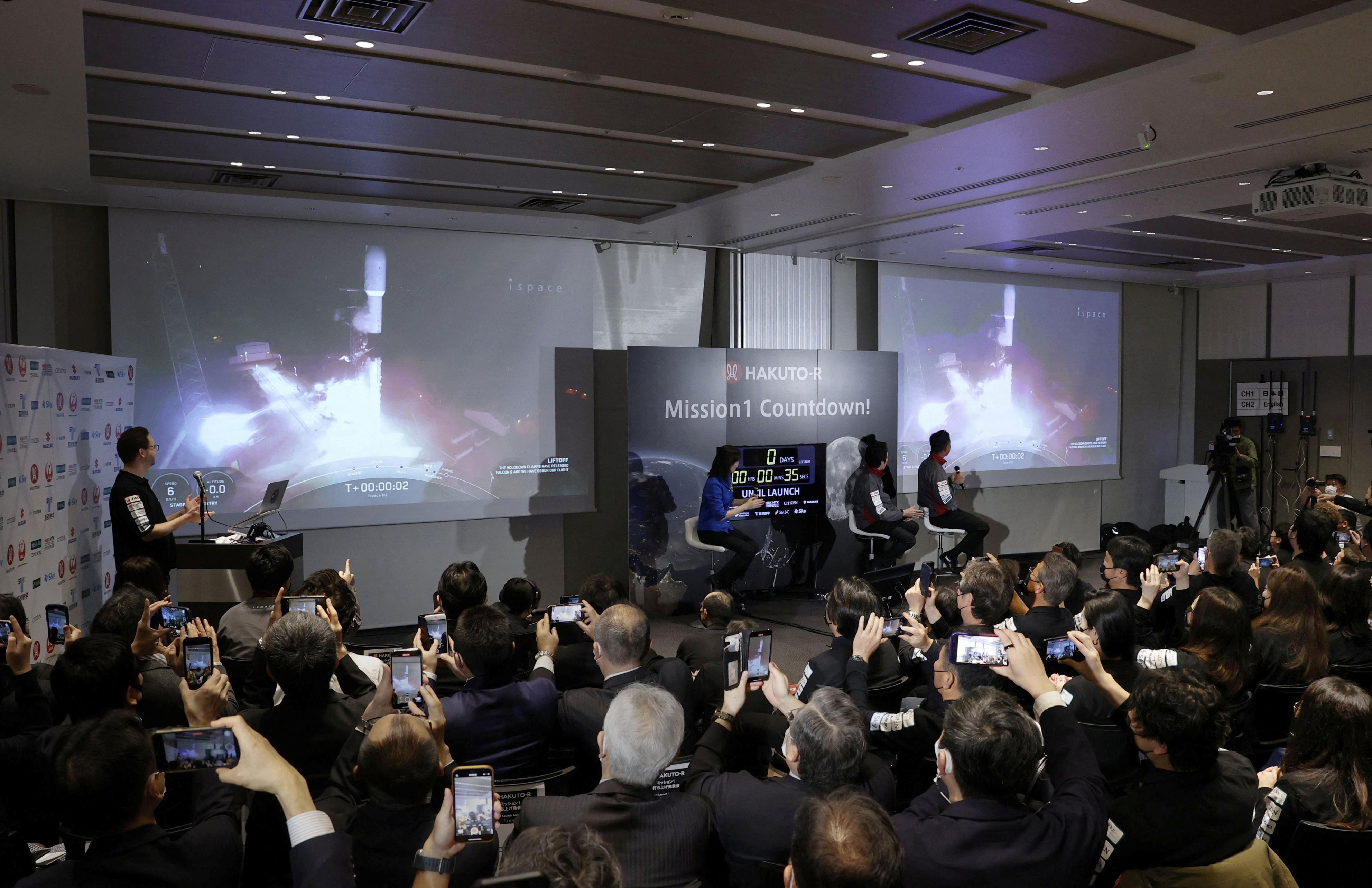 Officials of ispace Inc's HAKUTO-R mission look at live broadcasting of the launch of a SpaceX Falcon 9 rocket for ispace at Cape Canaveral Space Force Station