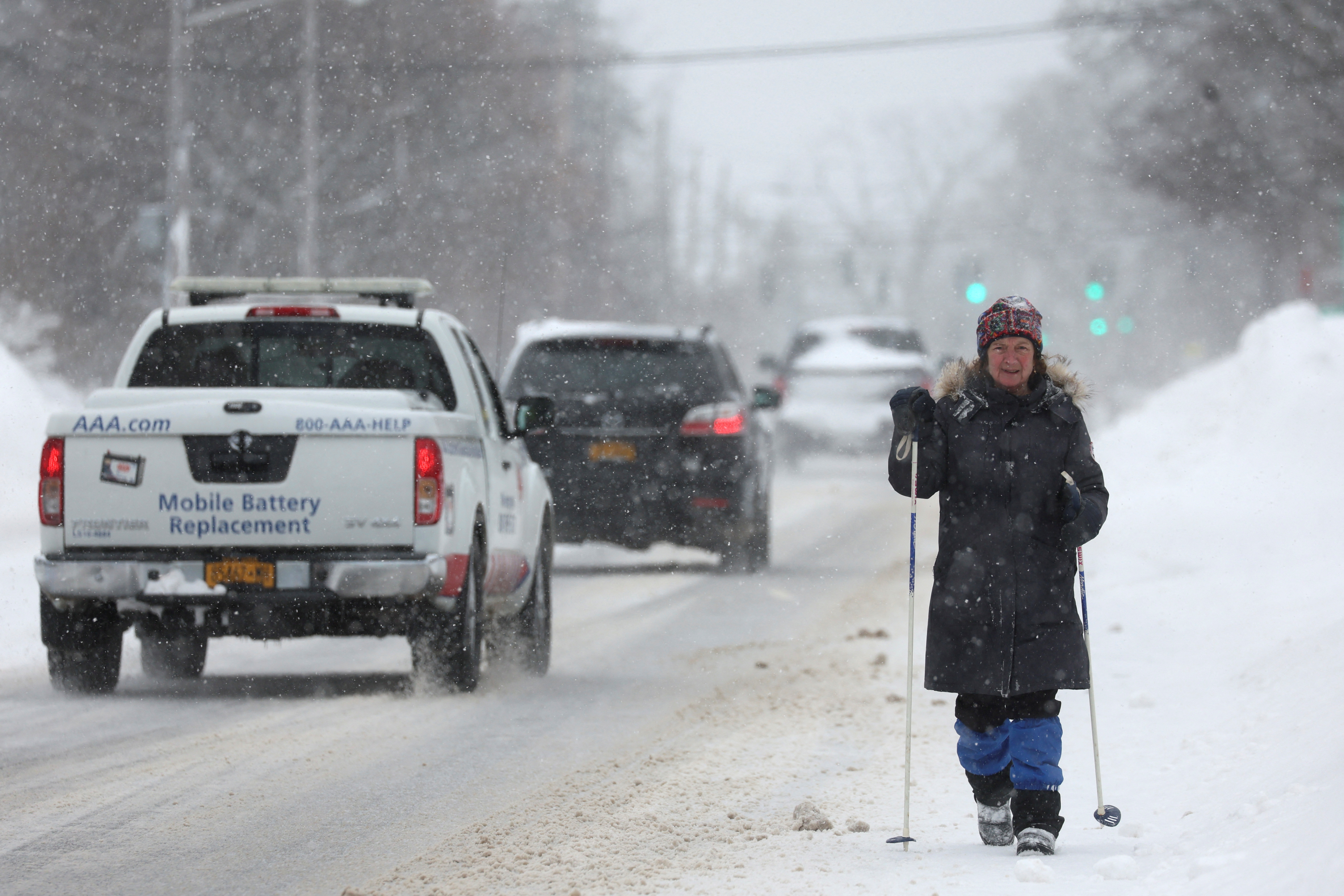 A woman steadies herself with ski poles in the snow in Amherst, New York, on December 26, 2022