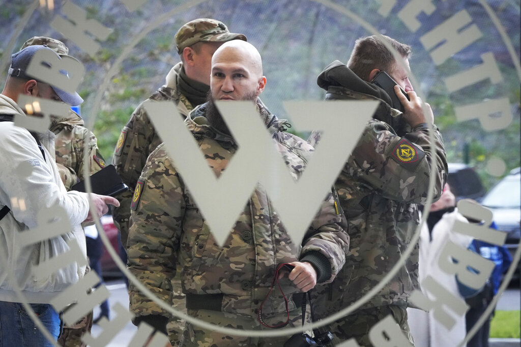 Visitors wearing military camouflage stand at the entrance of the Wagner Centre in St Petersburg, Russia, in November 2022