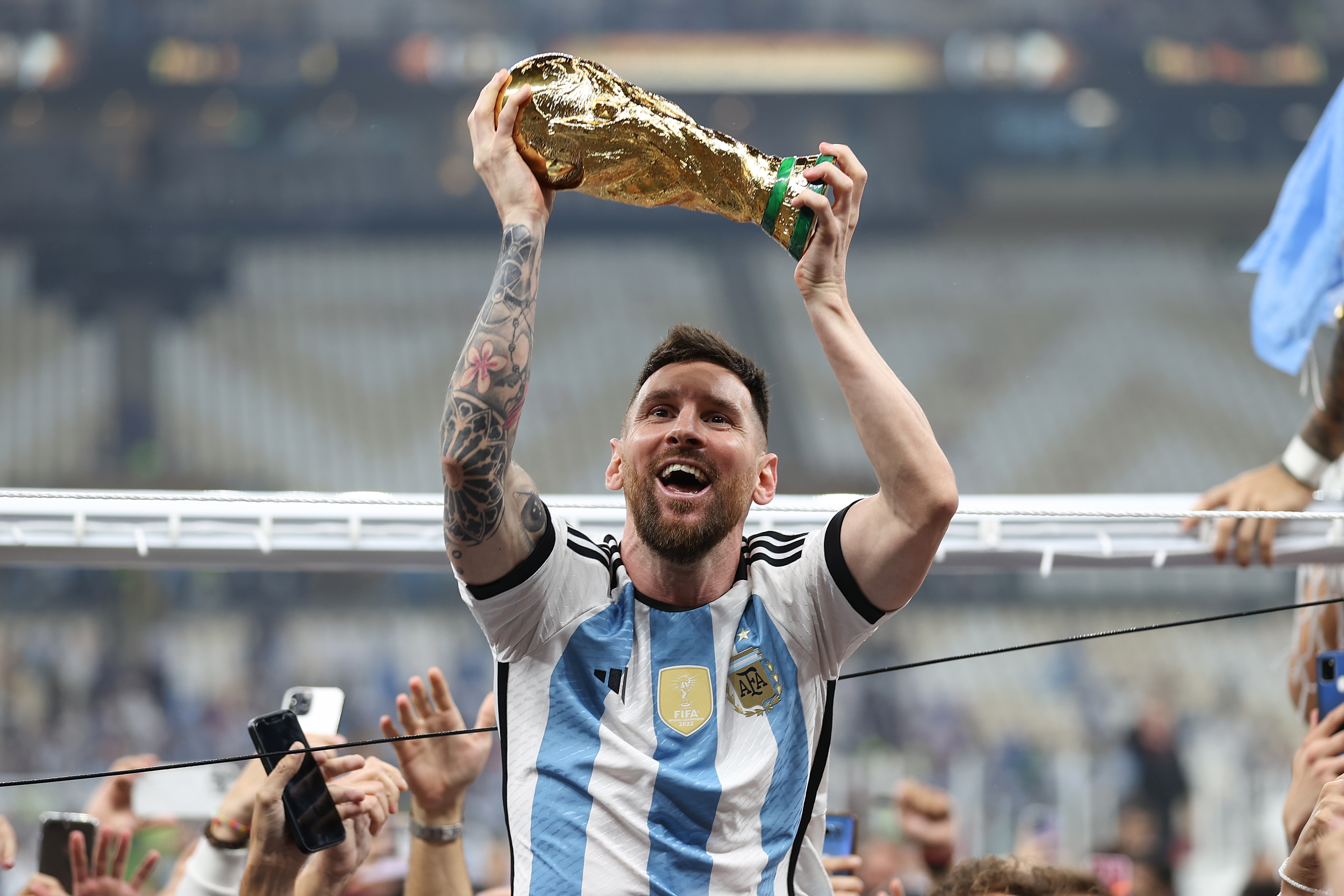 Lionel Messi holds the World Cup trophy aloft after Argentina’s victory over France in the World Cup final on December 18, 2022, in Lusail Stadium