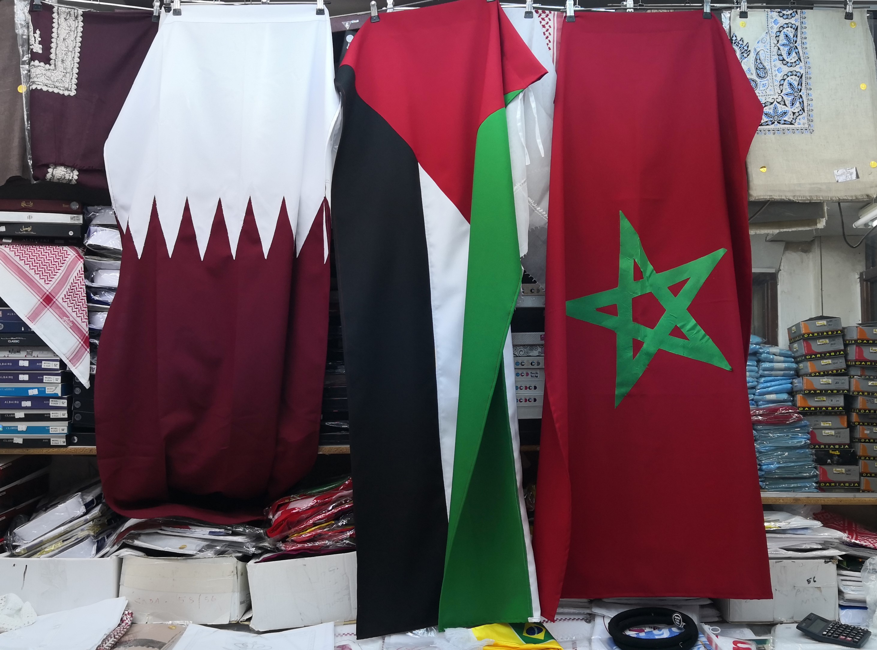 The Moroccan flag hangs next to the Qatar and Palestine flags in Souq Waqif in Doha