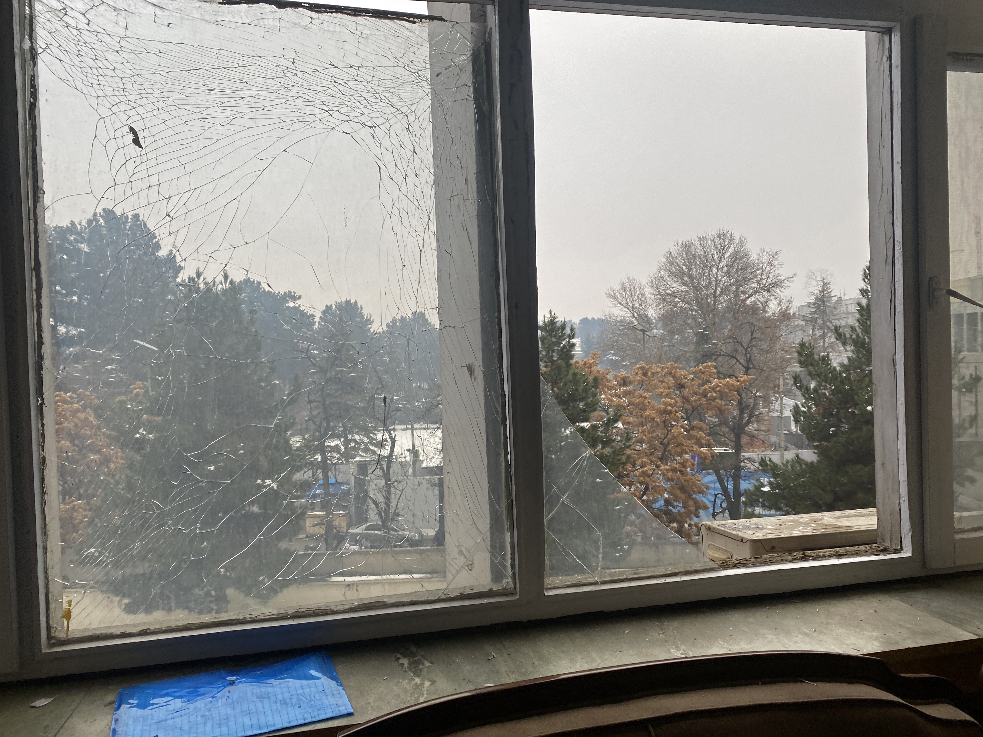 The broken windowpanes of a building are pictured after a suicide blast in Kabul