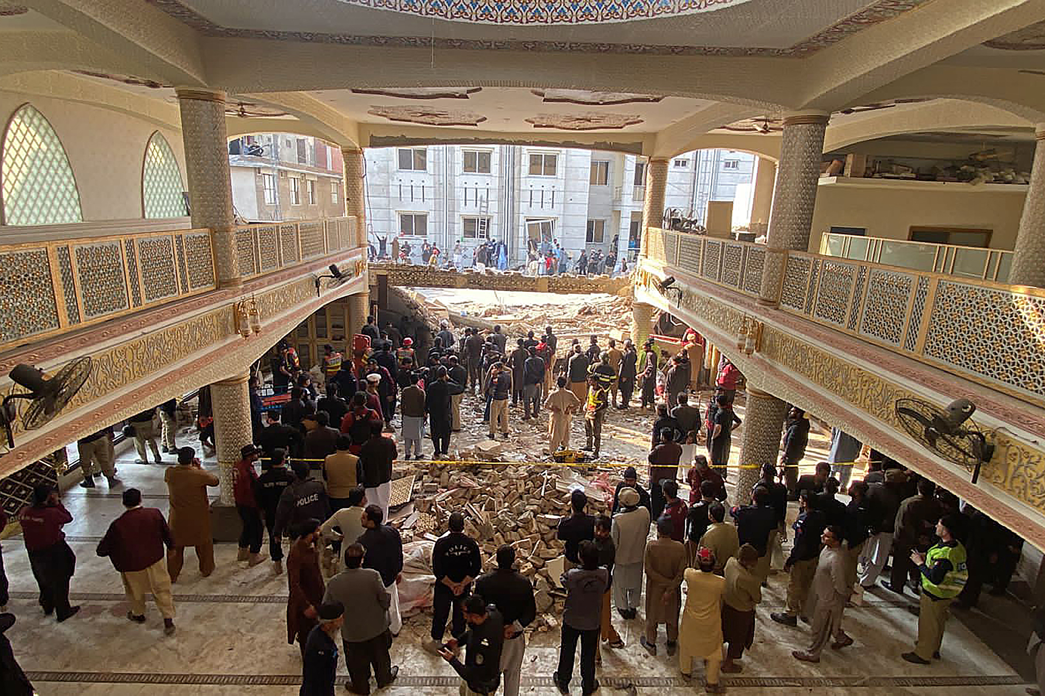 Security officials inspect the site of a mosque in Peshawar