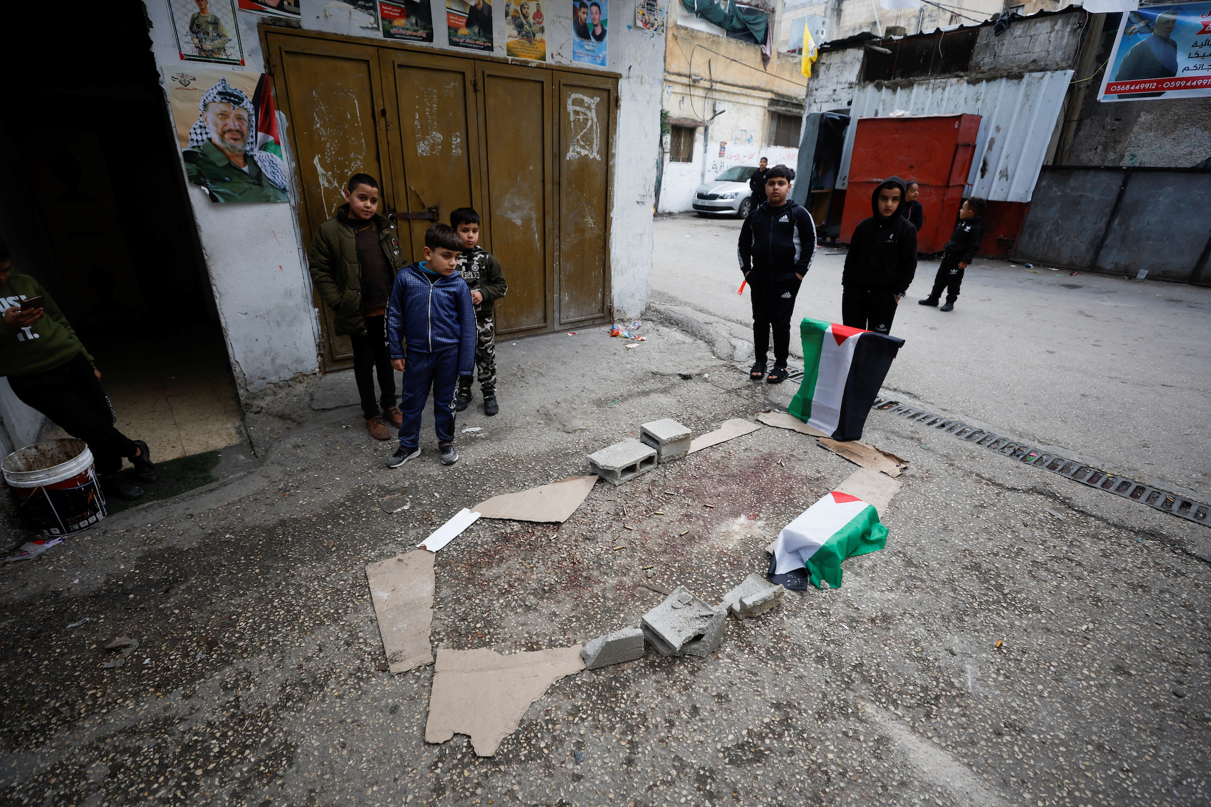 Children stand next to the site where a 16-year-old Palestinian was killed by the Israeli army int he West Bank.
