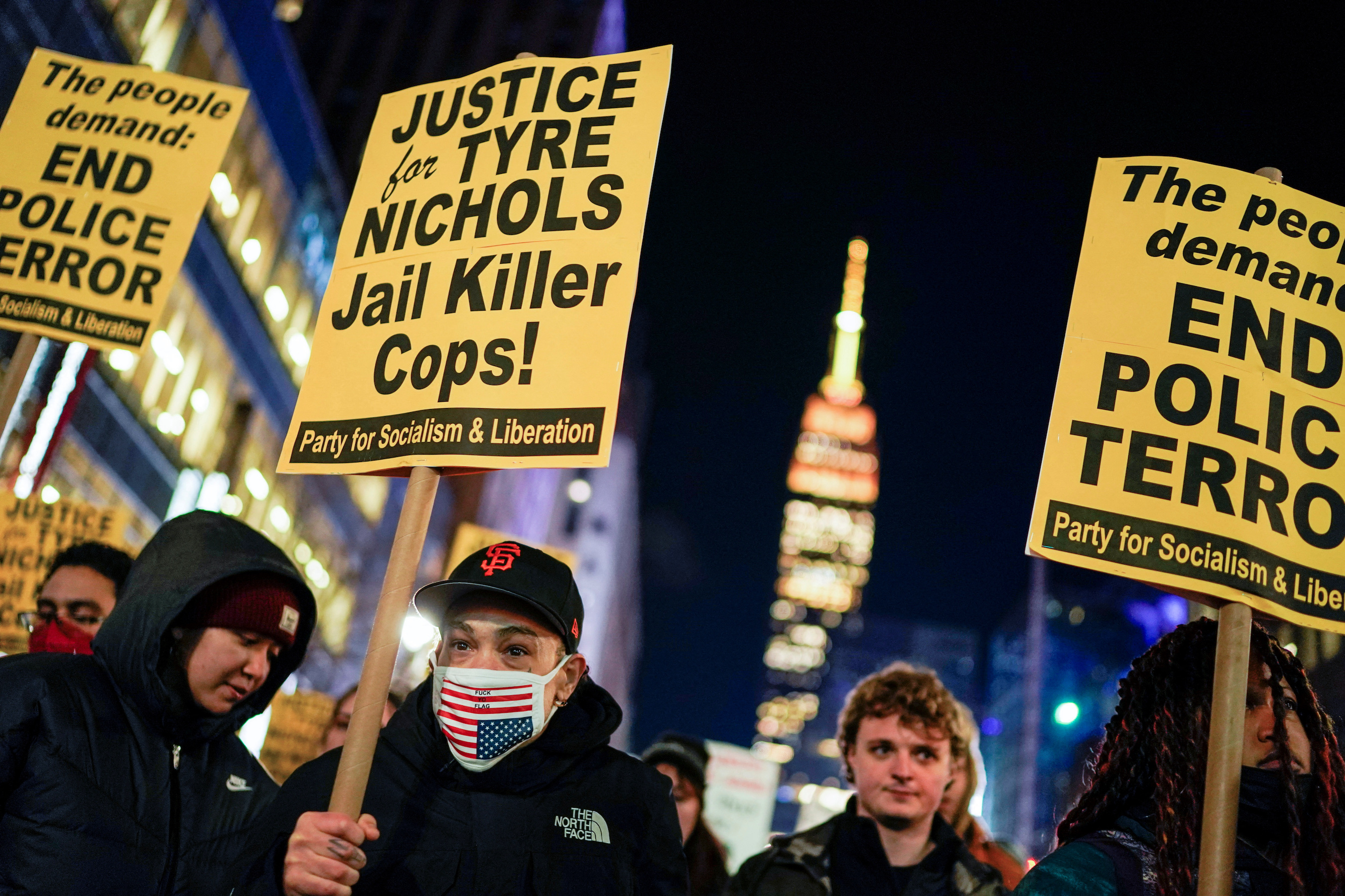 People hold placards at a protest on the day of the release of a video showing the Memphis police beating of Tyre Nichols