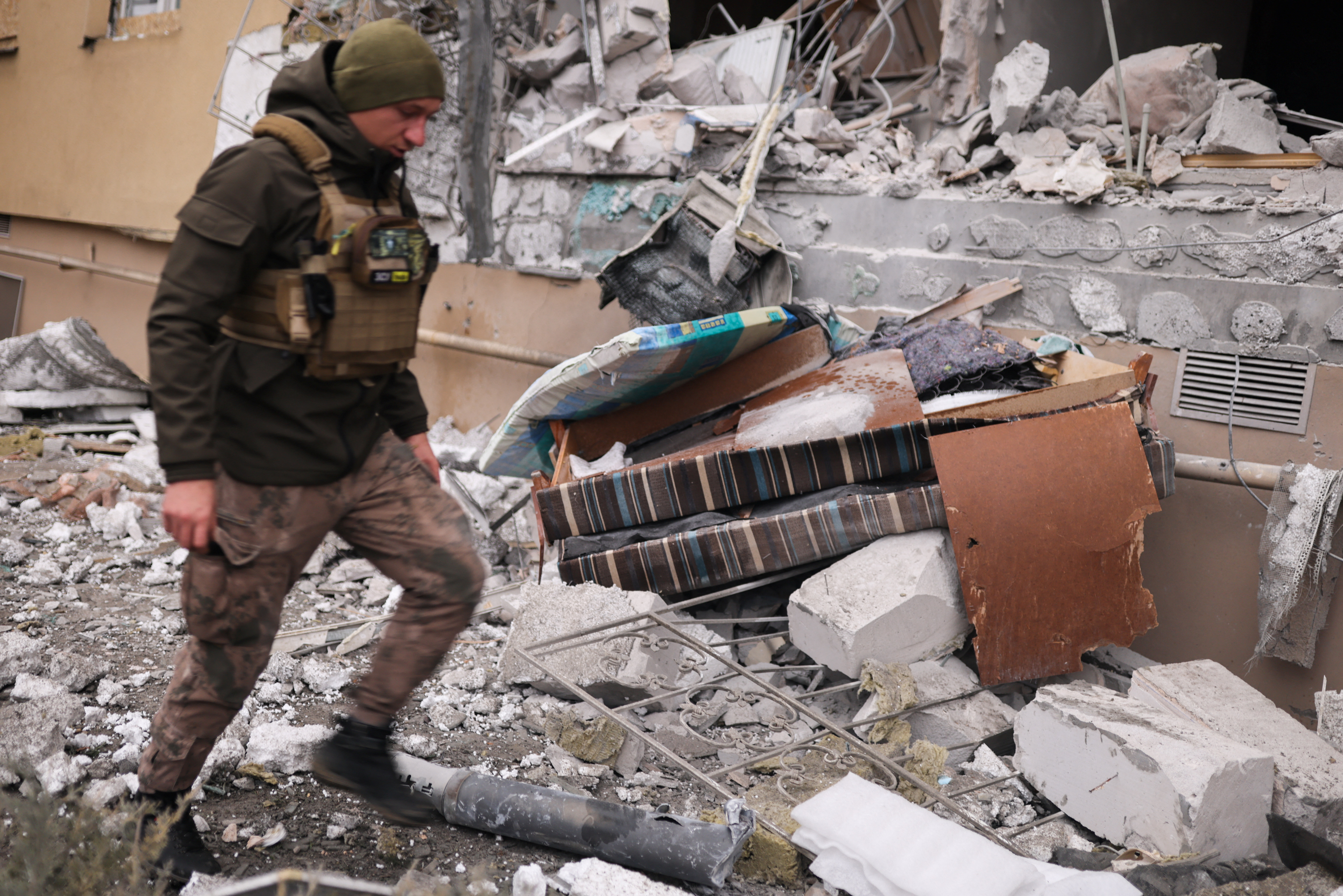 A Ukrainian serviceman walks as he removes a grad rocket in a damaged house after an attack, amid Russia's invasion of Ukraine, in Kherson, Ukraine