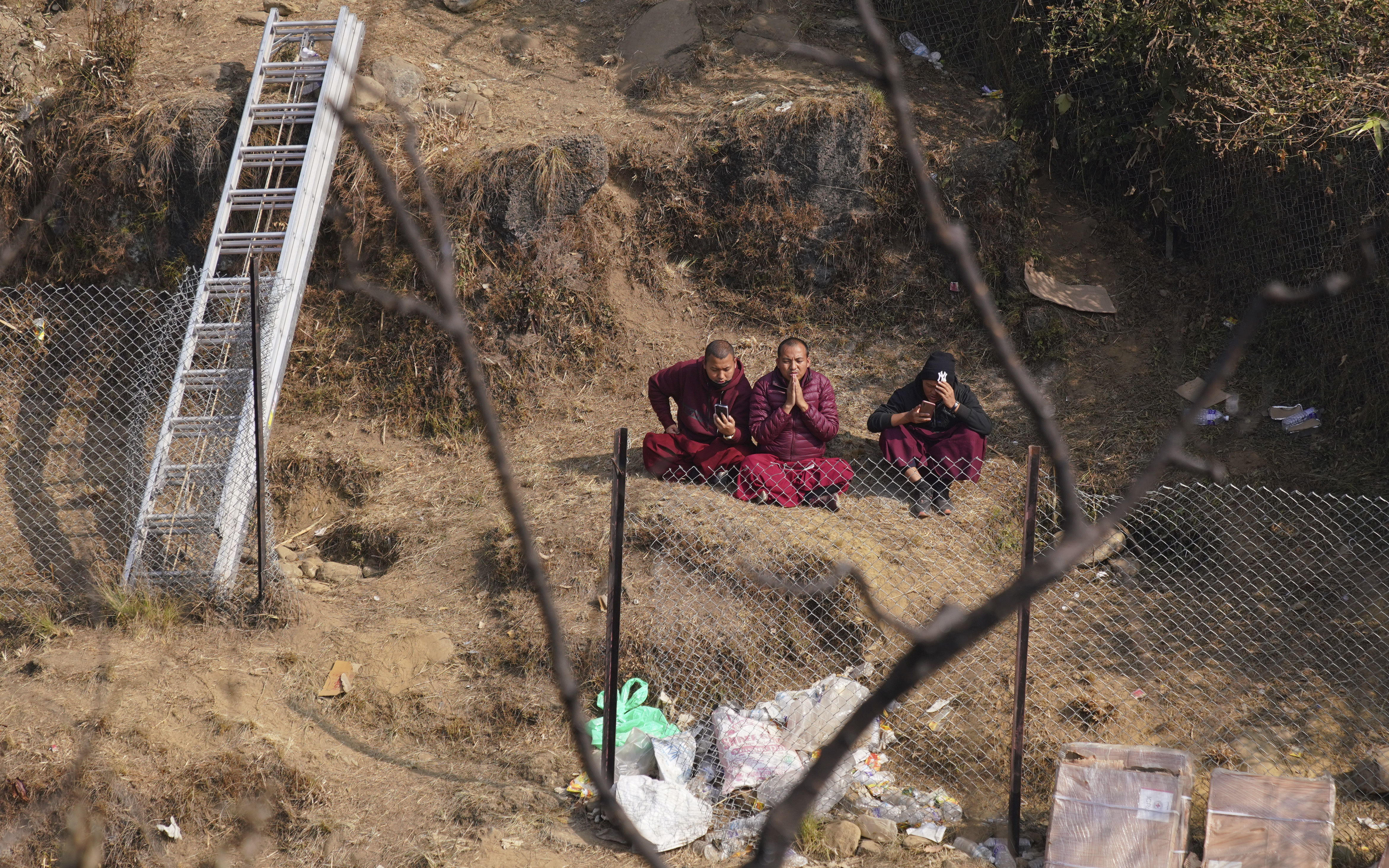 Buddhist monks pray for the victims at the crash site in Pokhara