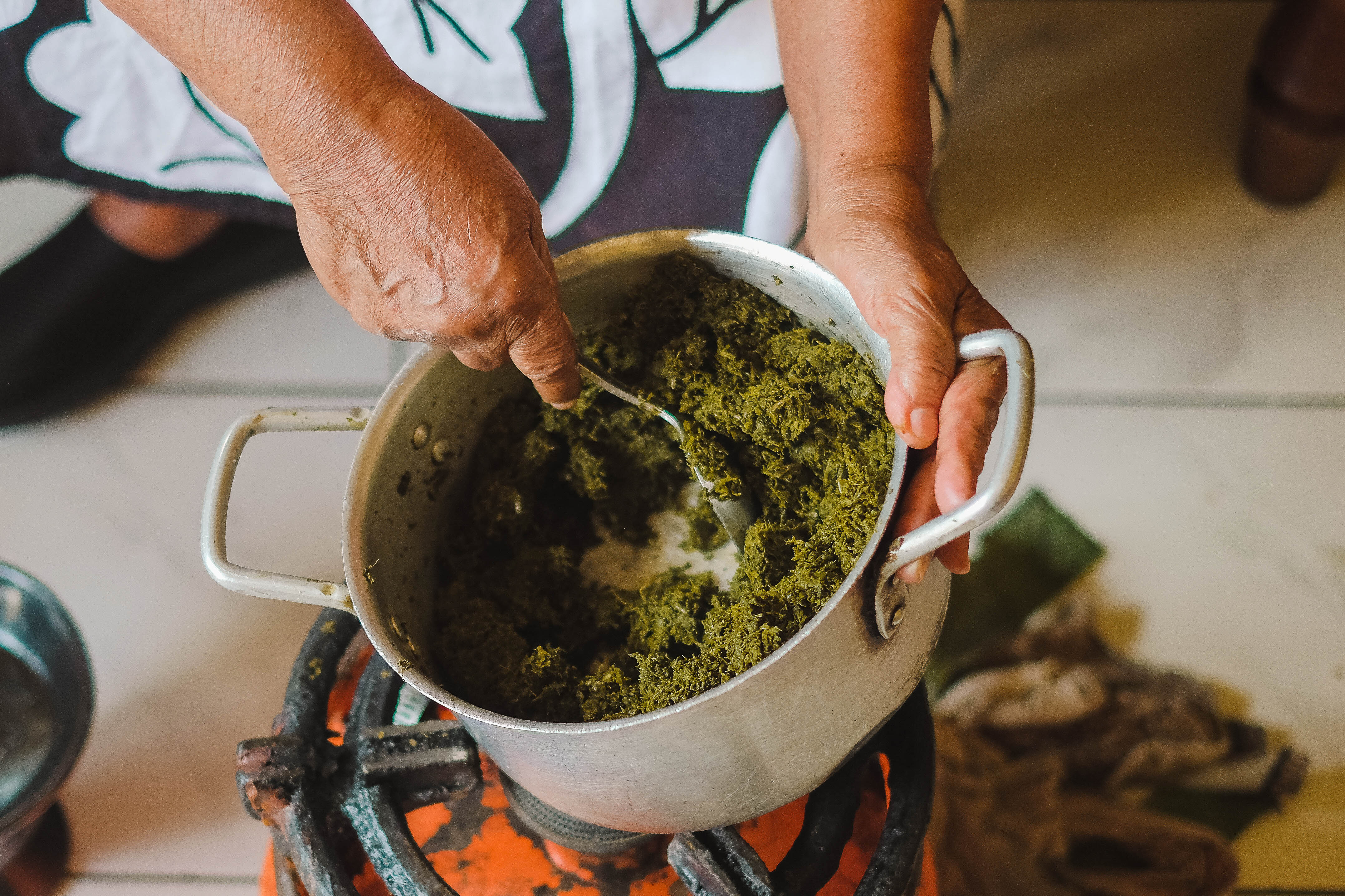 Bekelech gives a pot of gomen kitfo (Ethiopian collard greens) a final stir