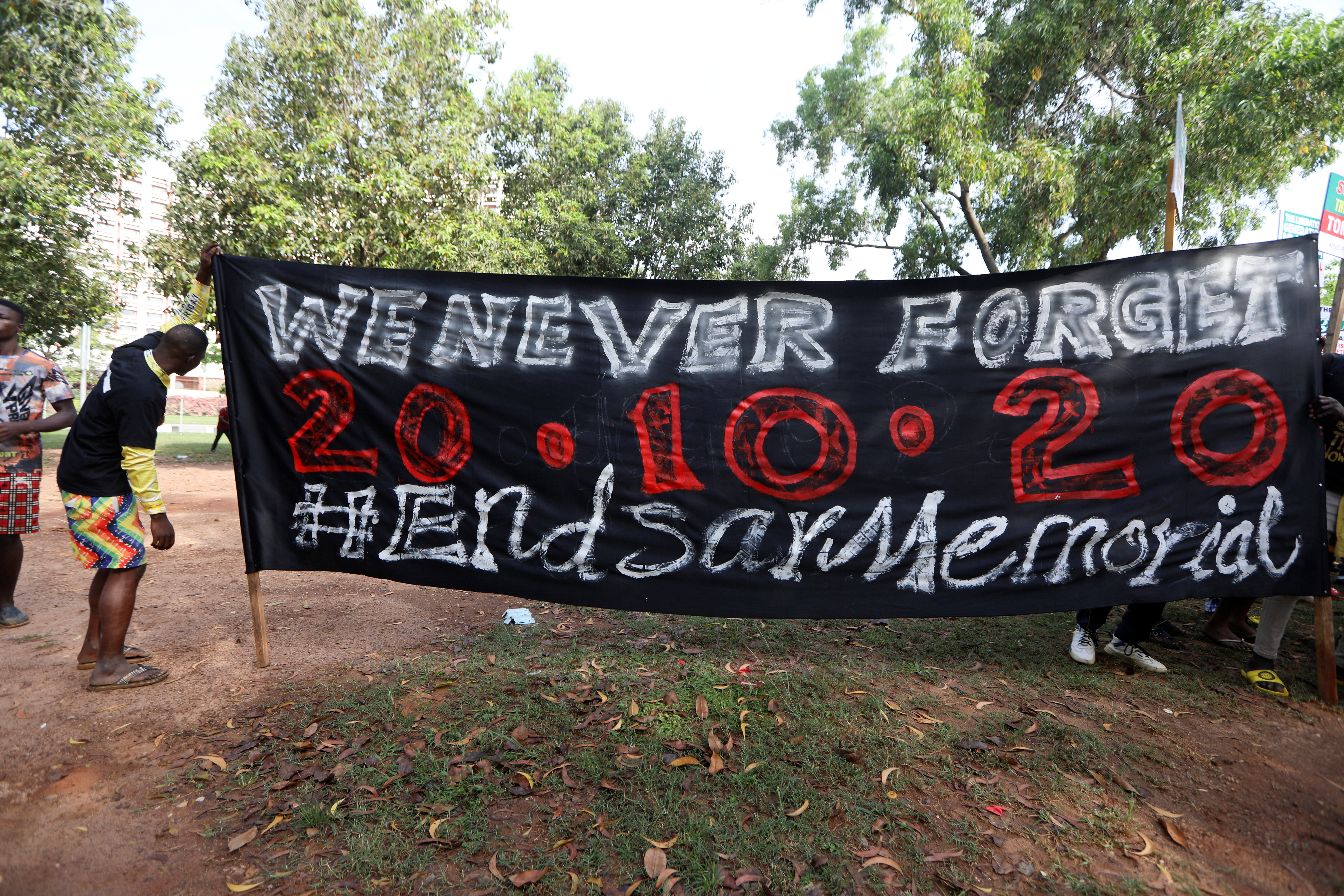 Protestors hold a poster as Nigerians mark the one-year anniversary of the EndSARS anti-police brutality