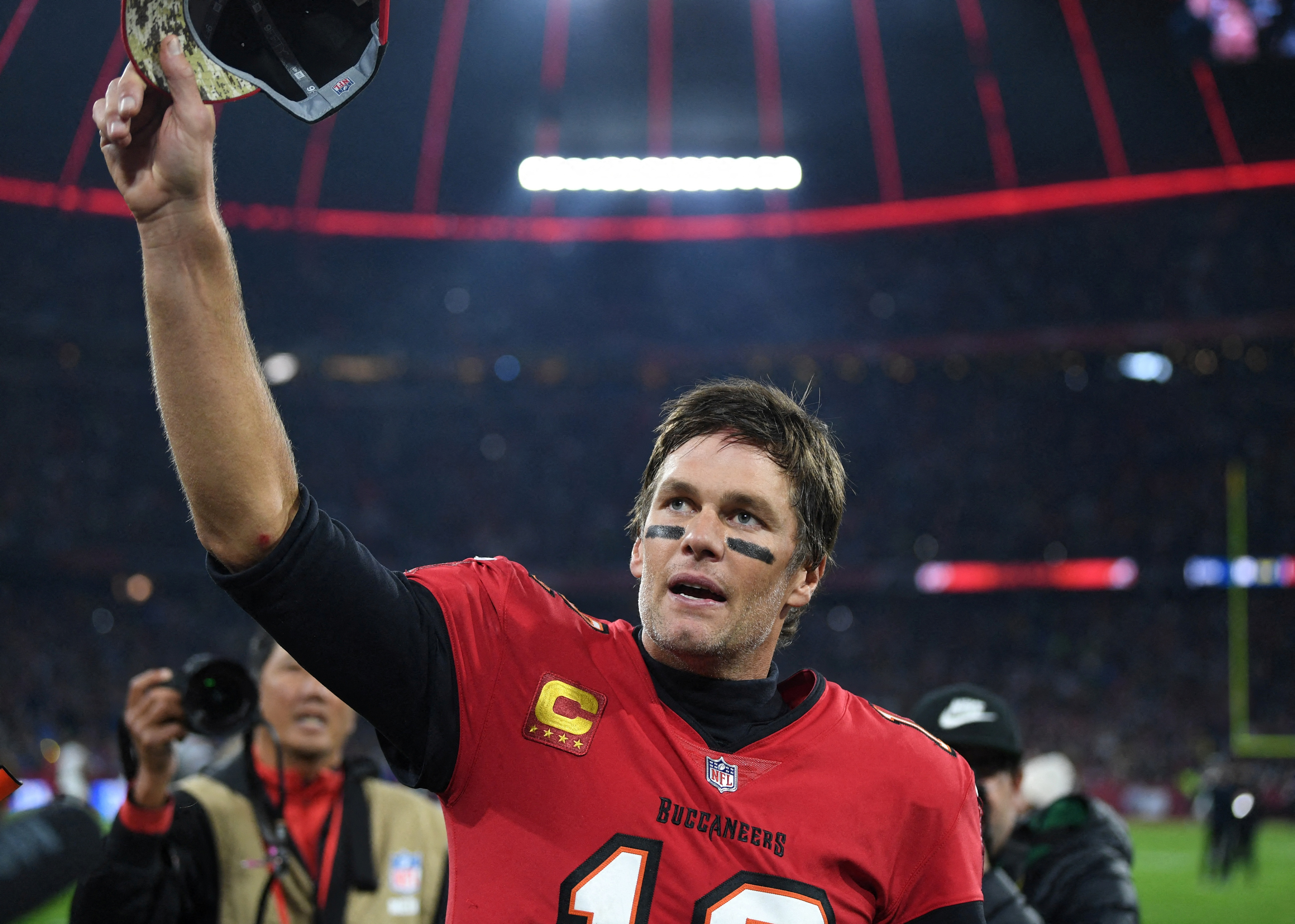 Tom Brady raises his right hand after an American football game